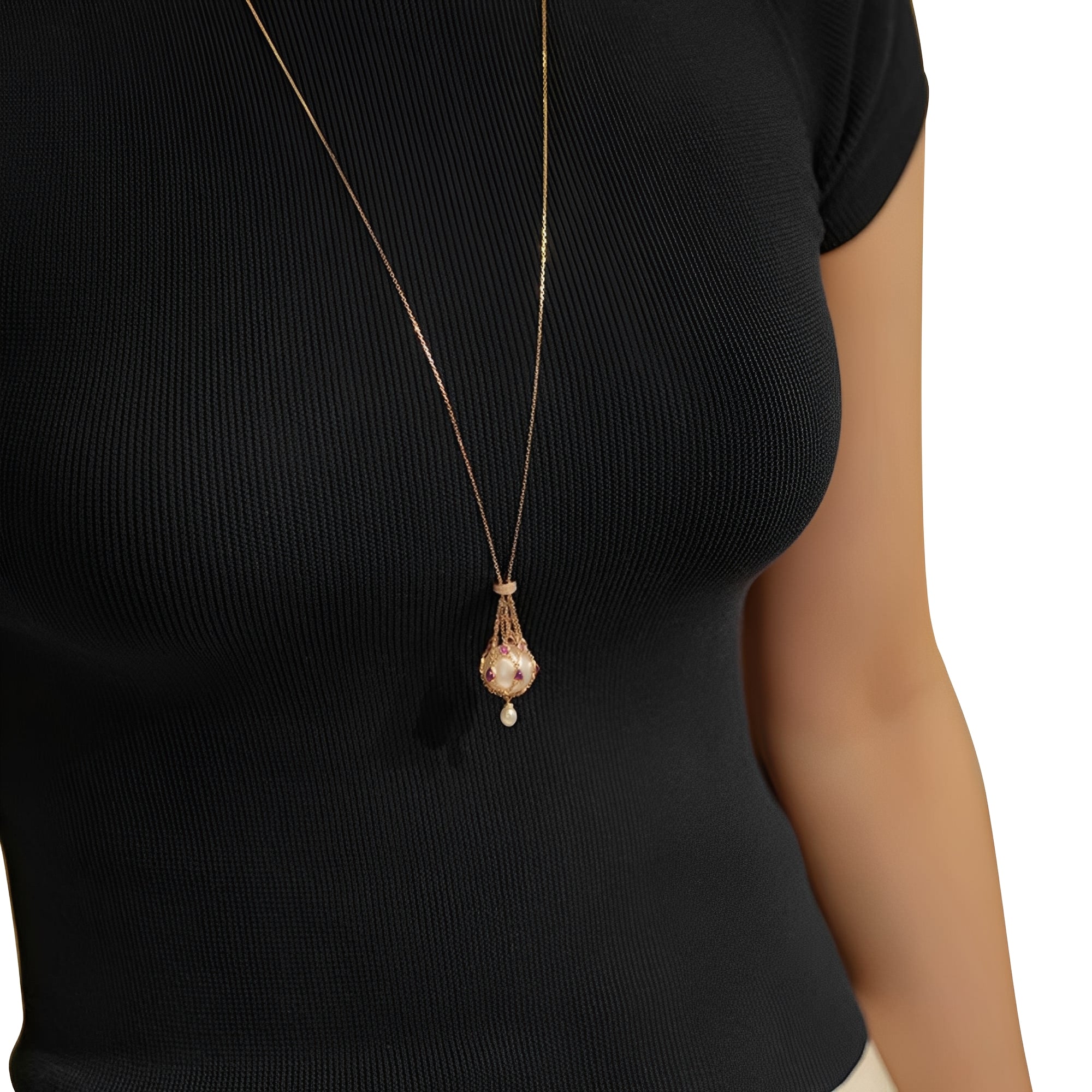 Gold pearl pendant necklace with ruby accents, featuring a large pearl encased in a gold chain cage with a smaller pearl drop