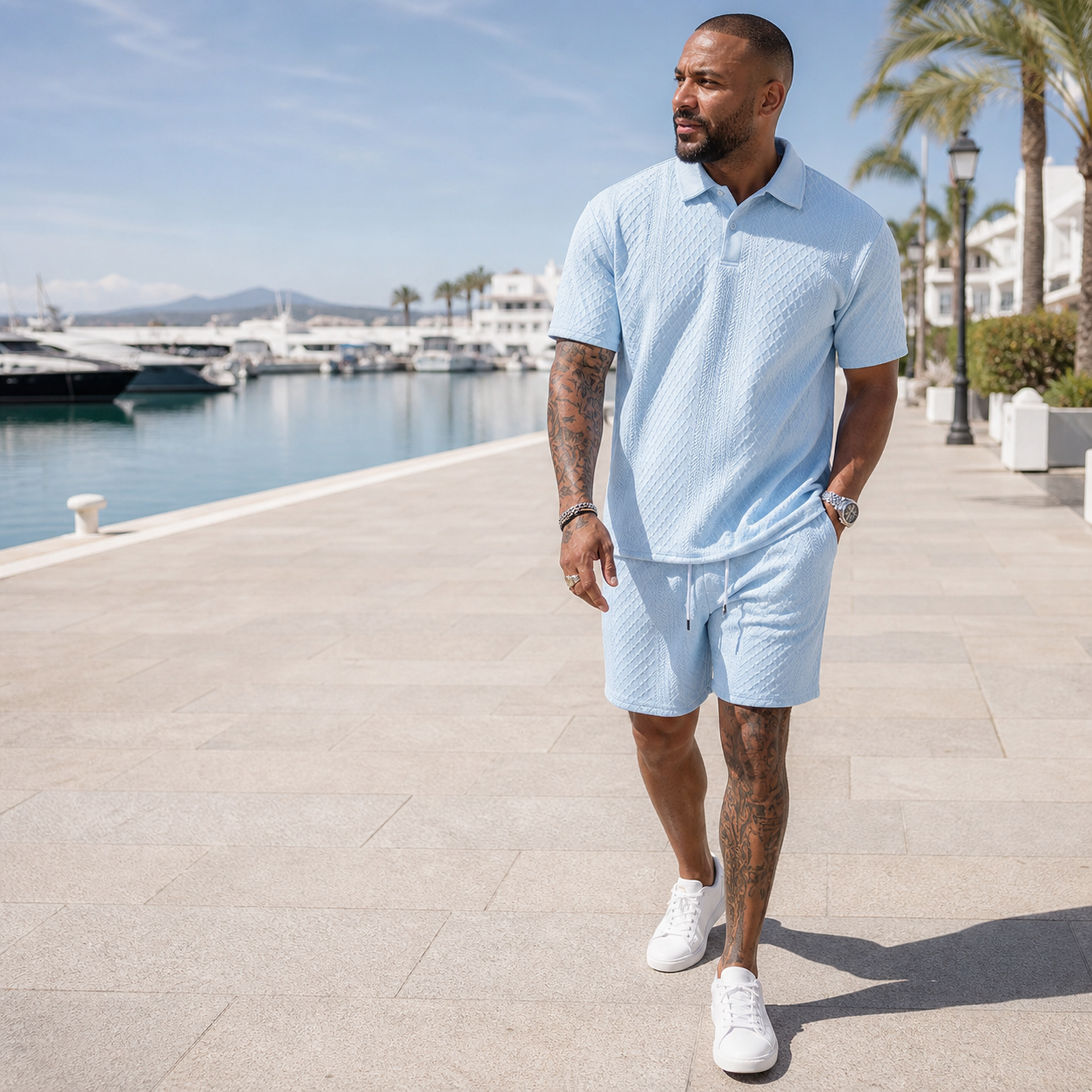 Man wearing light blue textured polo shirt and matching shorts near a marina