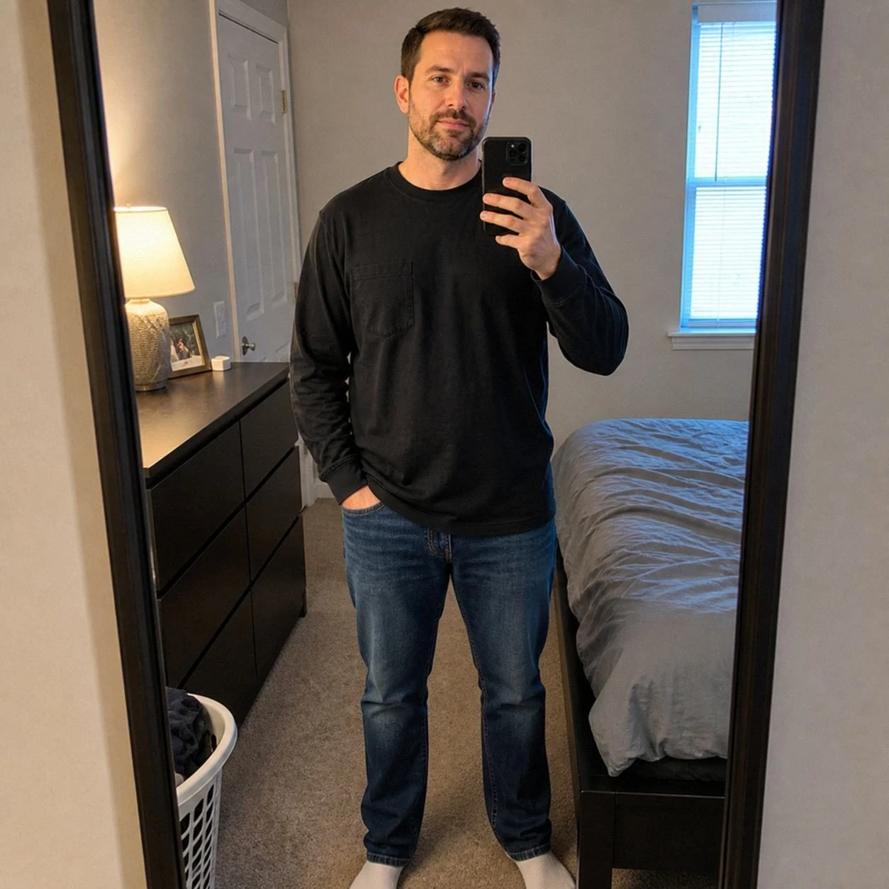 Black long sleeve pocket T-shirt in an ordinary bedroom mirror phone photo