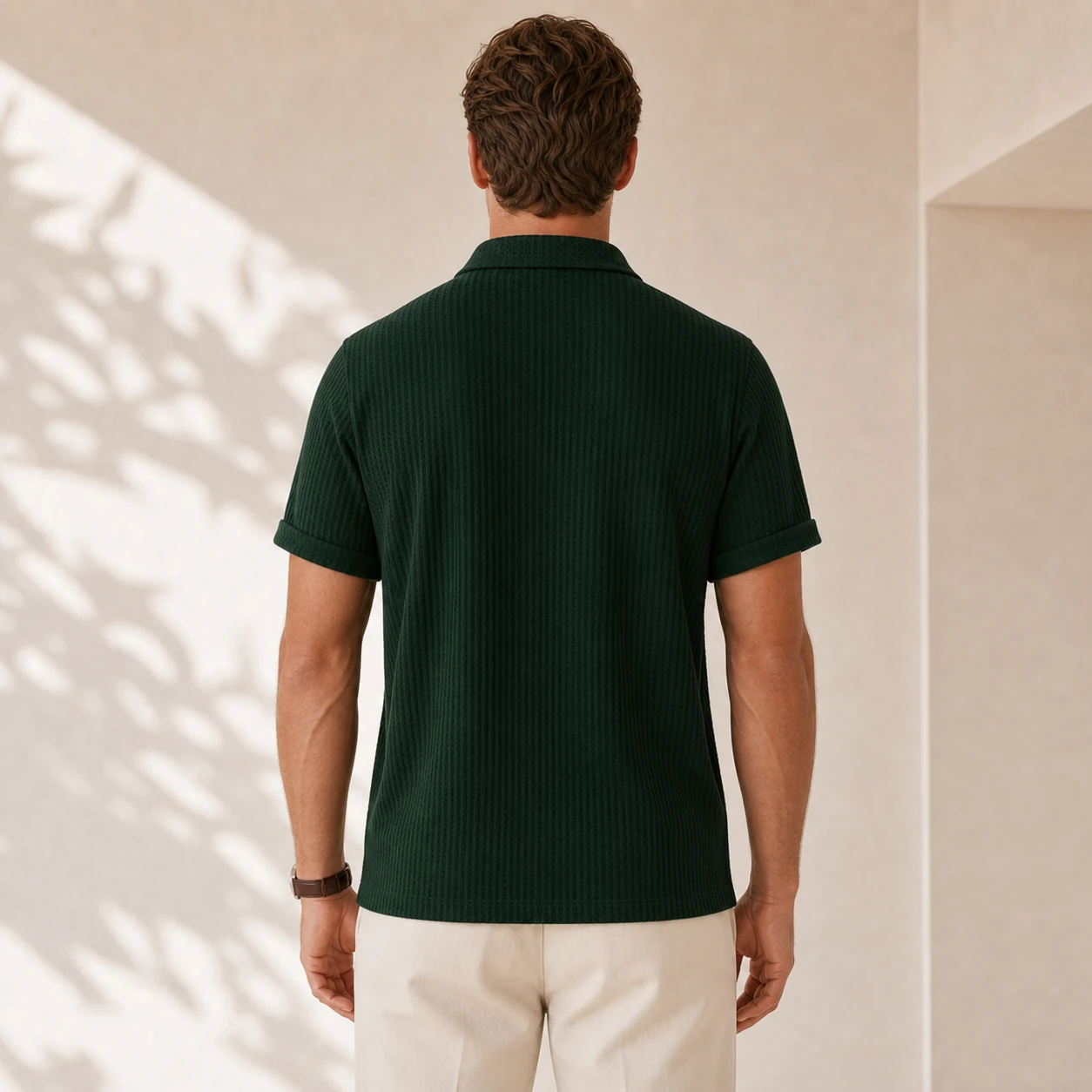 Back view of a men's dark green jacquard knit polo shirt