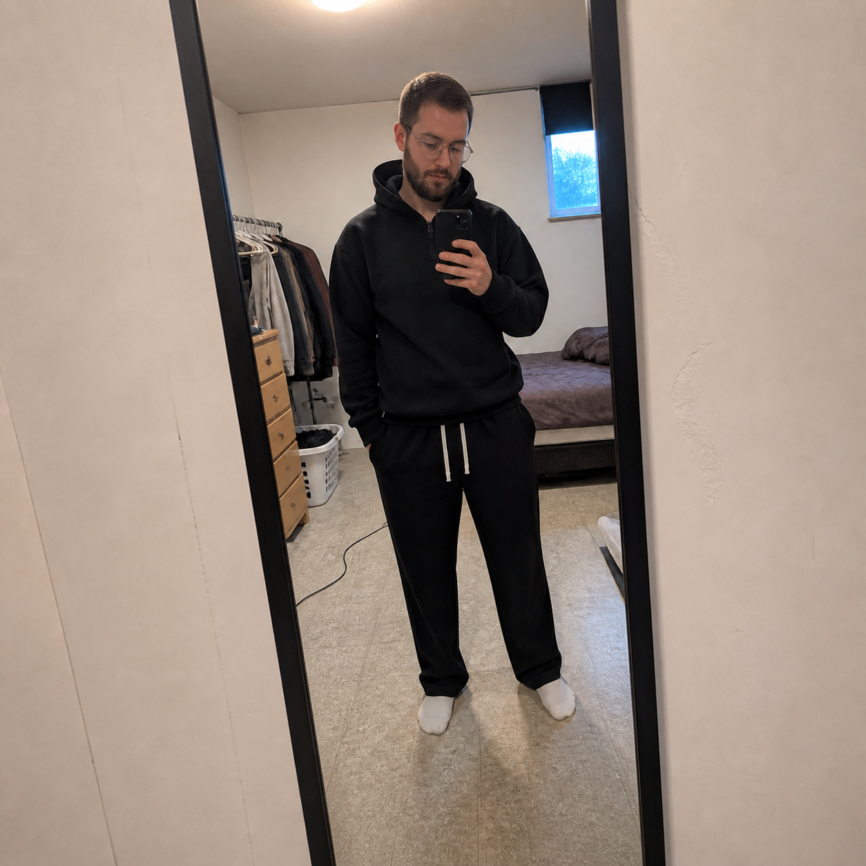 Black sweatsuit in an ordinary bedroom mirror phone photo