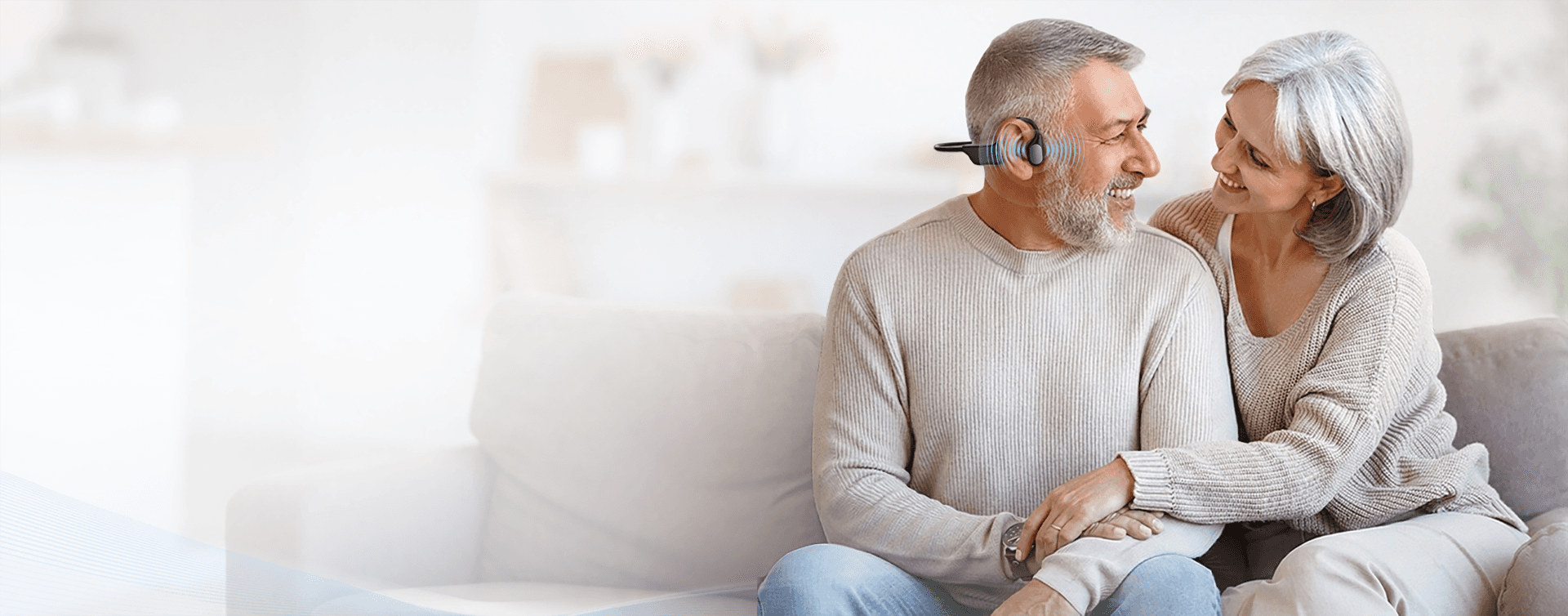 Older couple enjoying a relaxed conversation while using open-ear bone conduction hearing technology