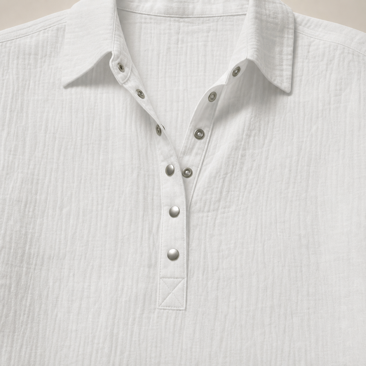 Gros plan du col pointu et de la patte Henley &agrave; boutons-pression de la blouse blanche