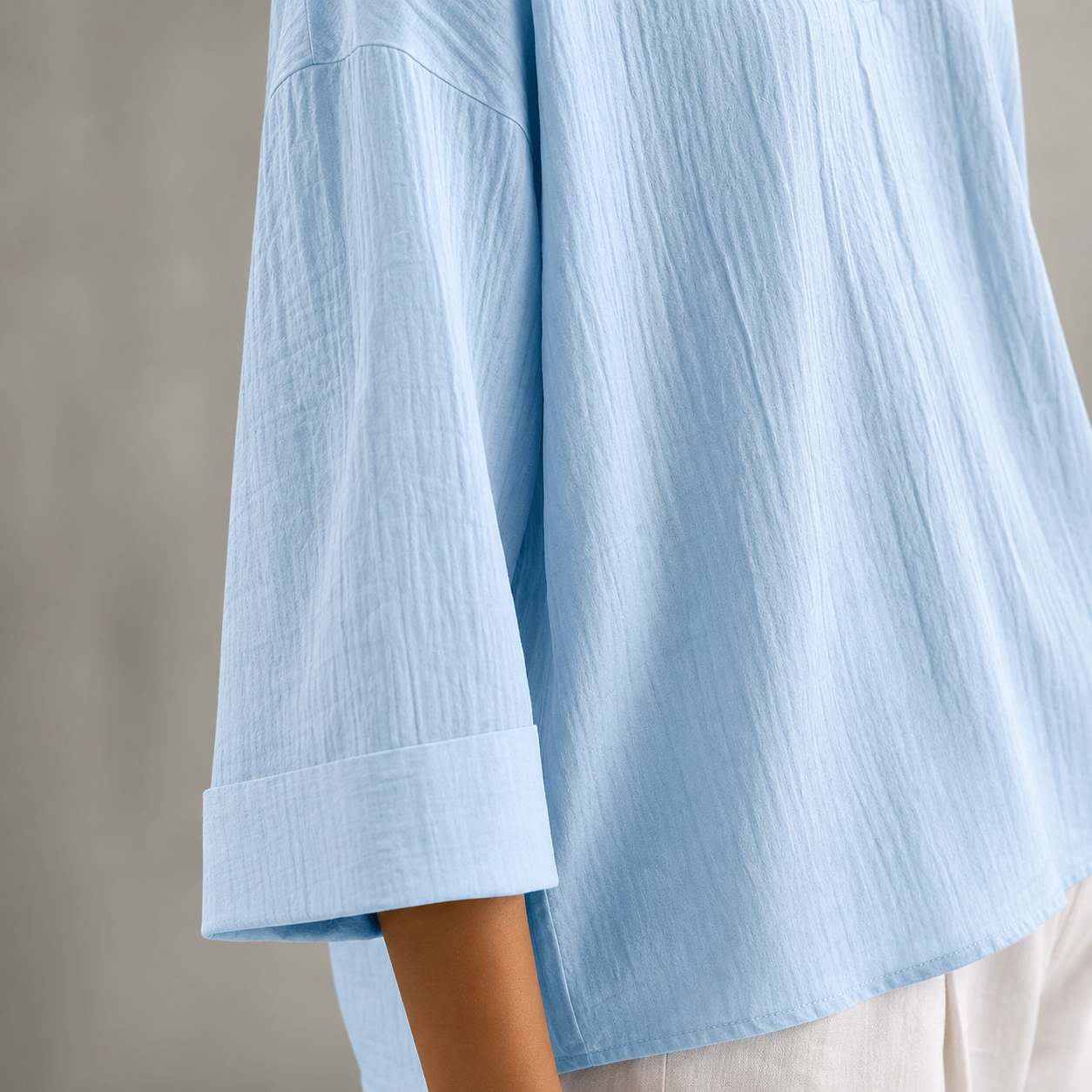 Gros plan de la manche trois quarts, du poignet et de la texture de la blouse bleu ciel