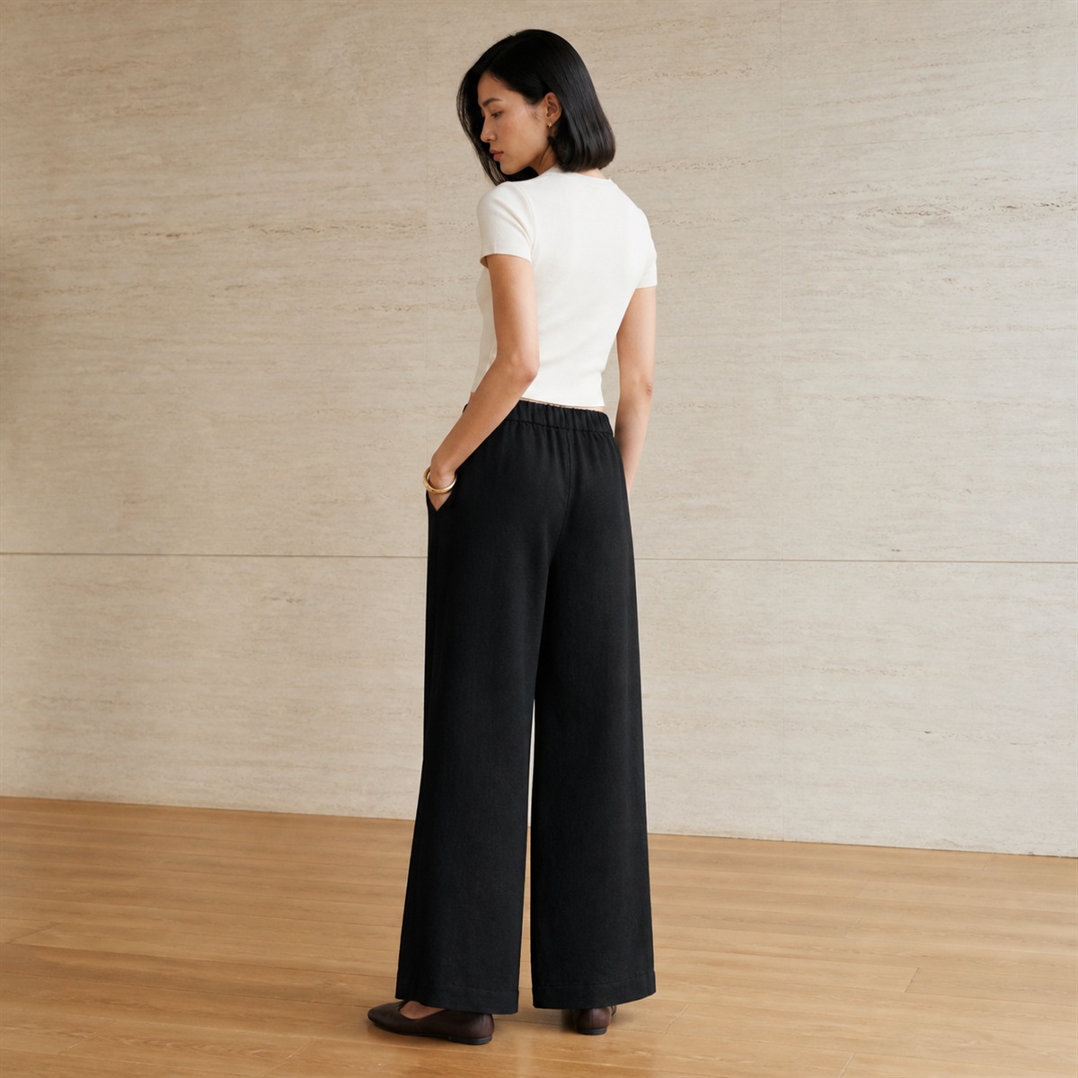 Pantalon en lin noir porté de profil et de dos