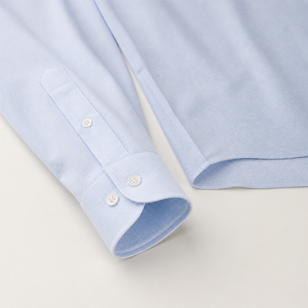 Détail du poignet boutonné et de l'ourlet de chemise