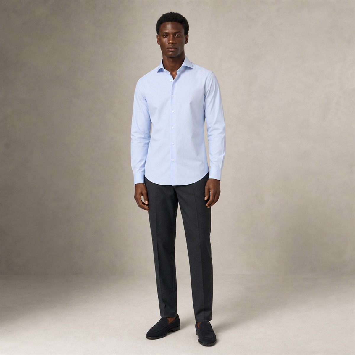 Chemise bleu ciel portée sous un costume marine