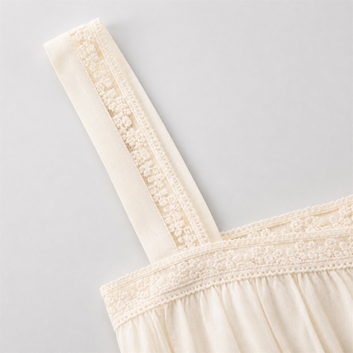 Détail des bretelles larges et de la dentelle