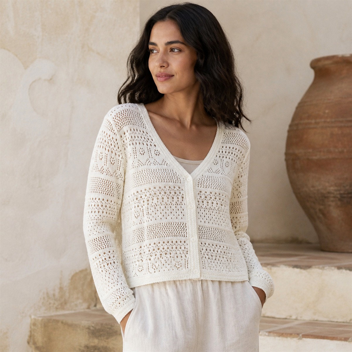 Cardigan blanc cassé porté sur une terrasse lumineuse