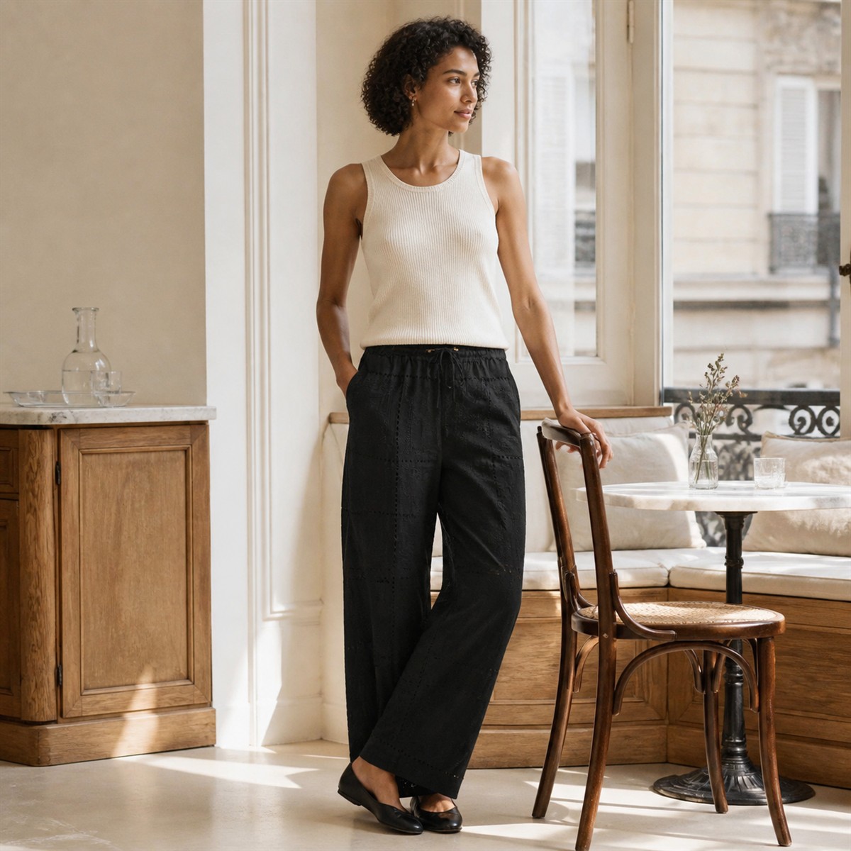 Pantalon noir brodé porté dans un café lumineux