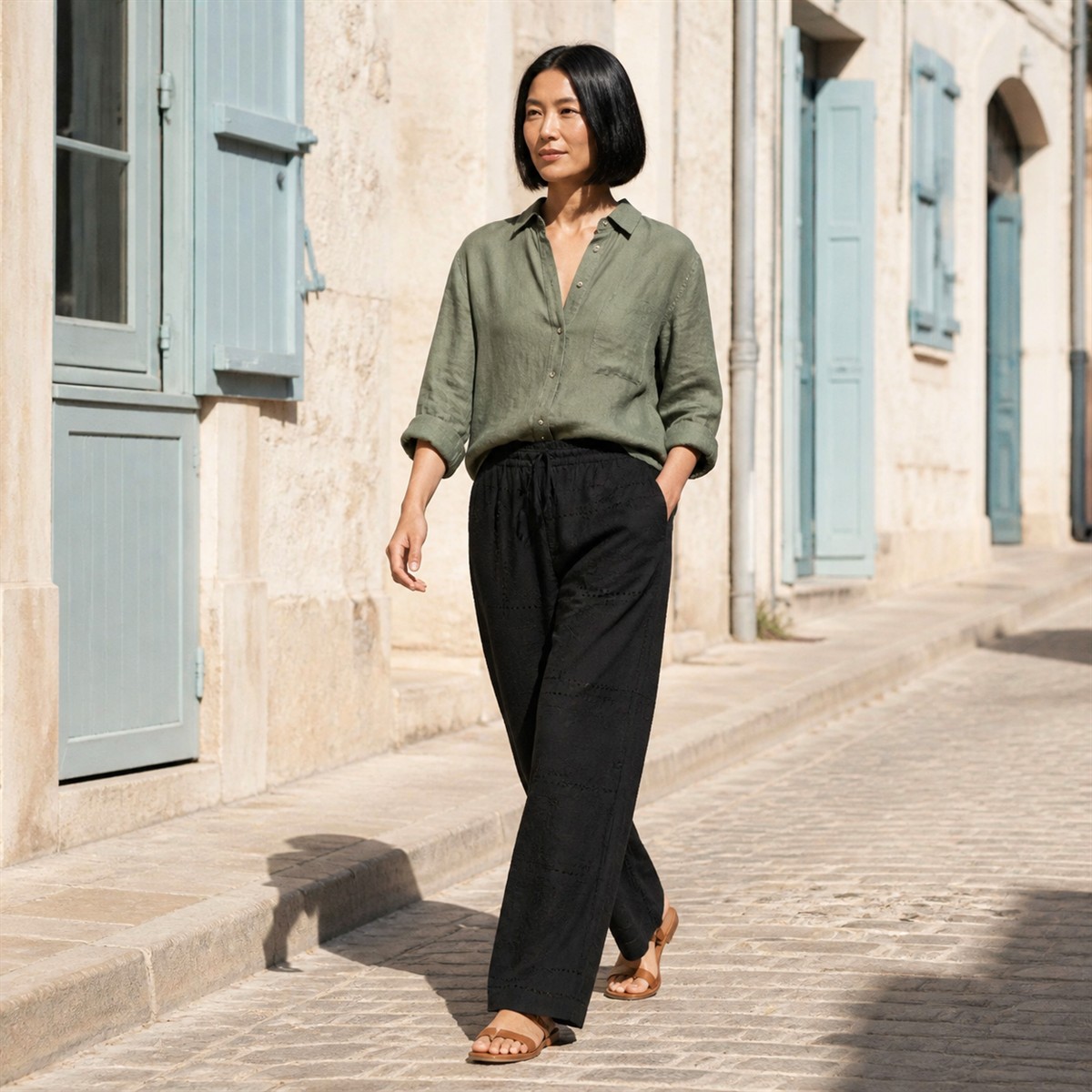 Pantalon noir brodé porté dans une rue méditerranéenne