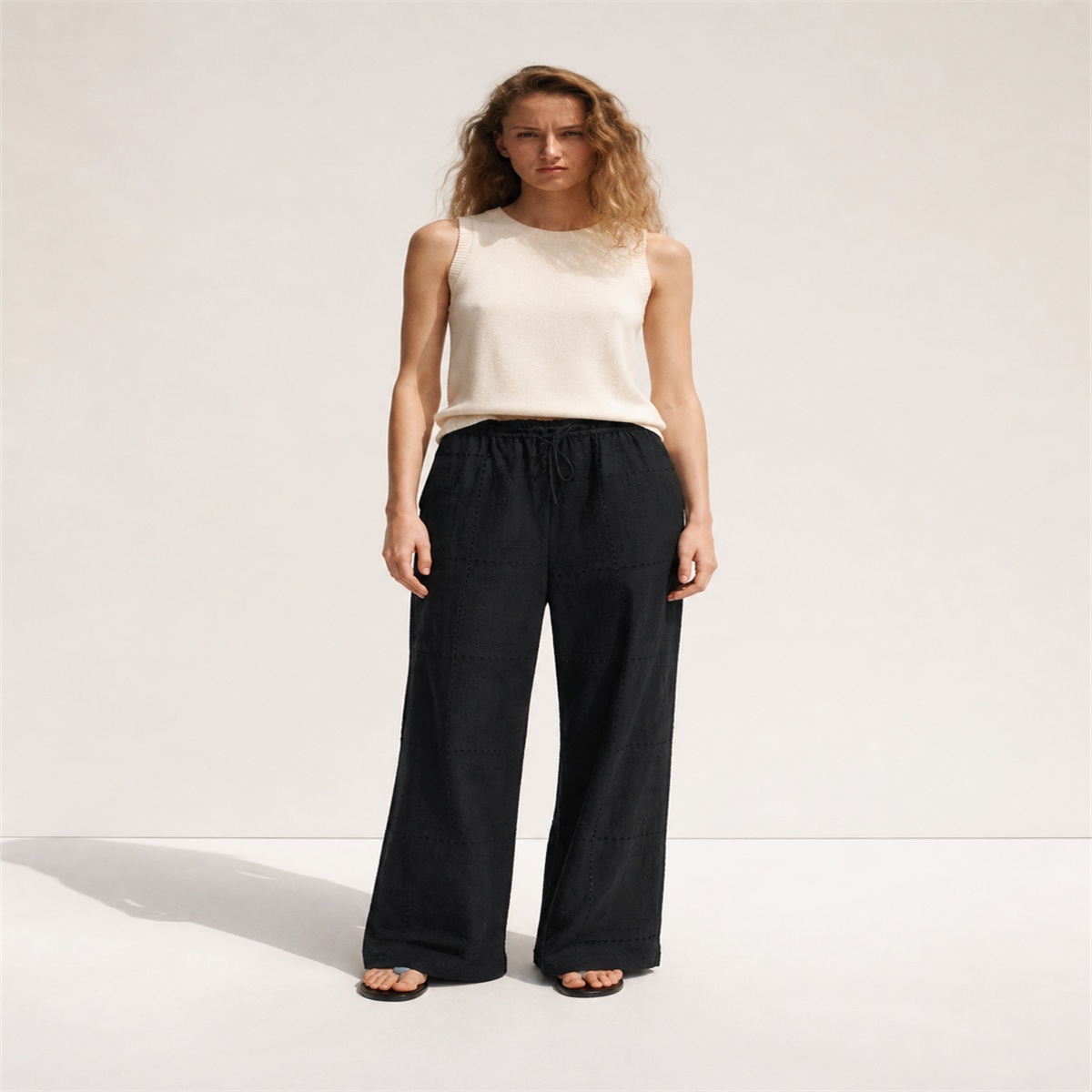 Pantalon noir brodé porté de face