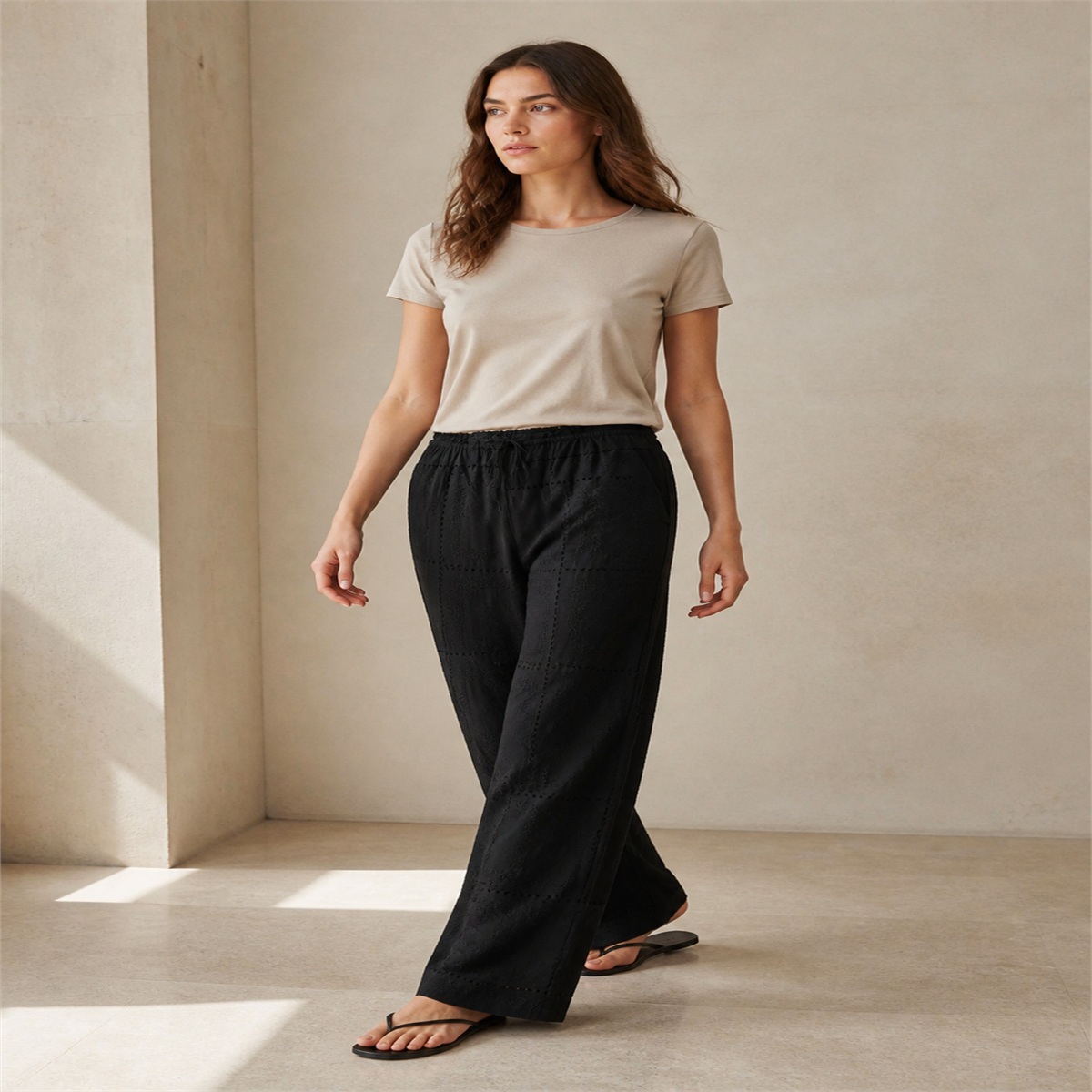 Pantalon noir brodé porté de trois quarts