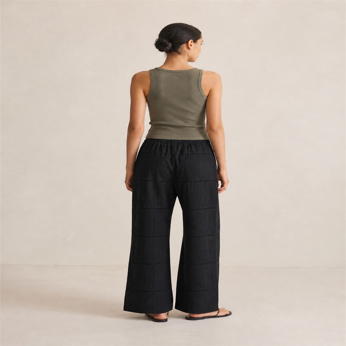 Pantalon noir brodé porté de dos