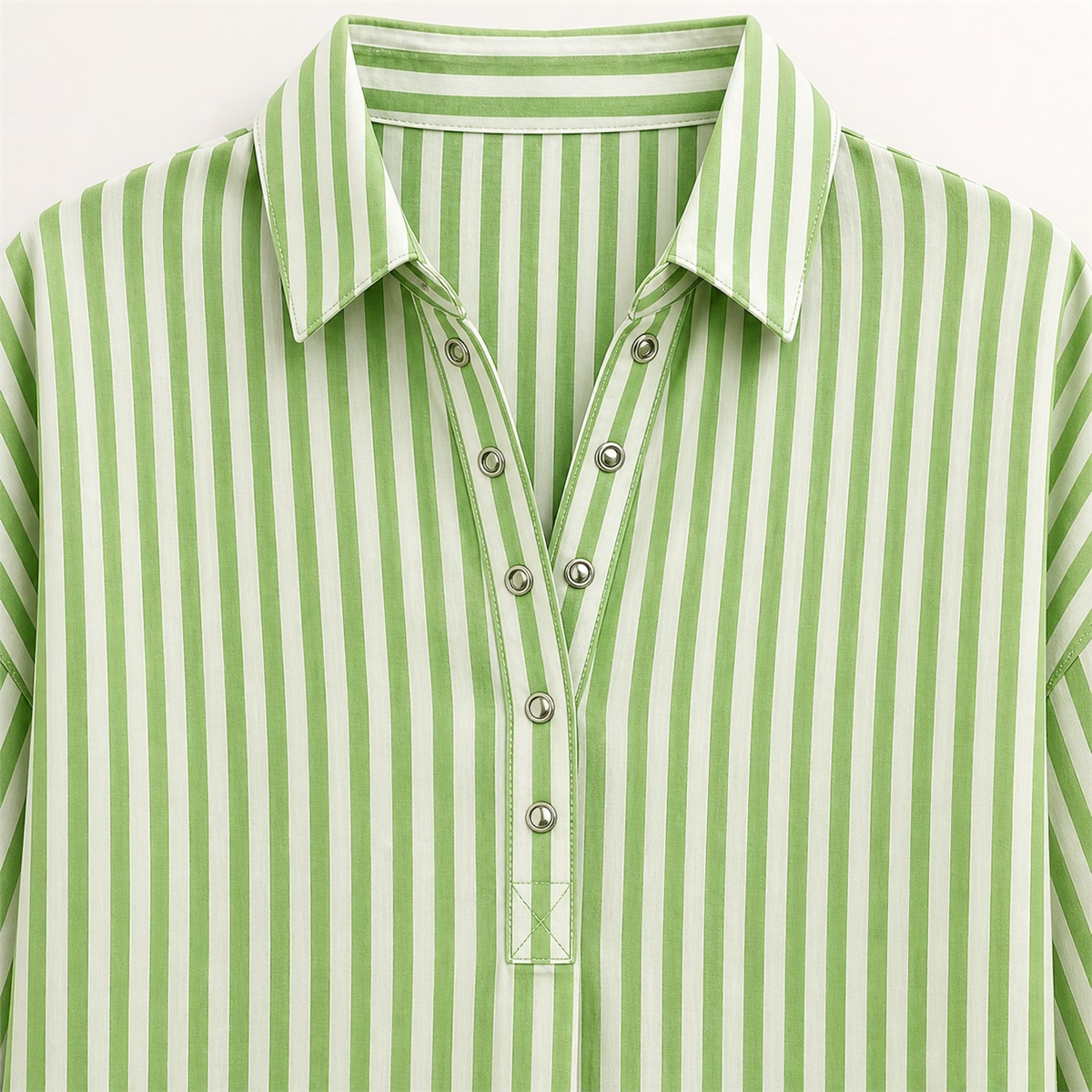 D&eacute;tail du col chemise vert et de la demi-patte avec petites pressions m&eacute;talliques