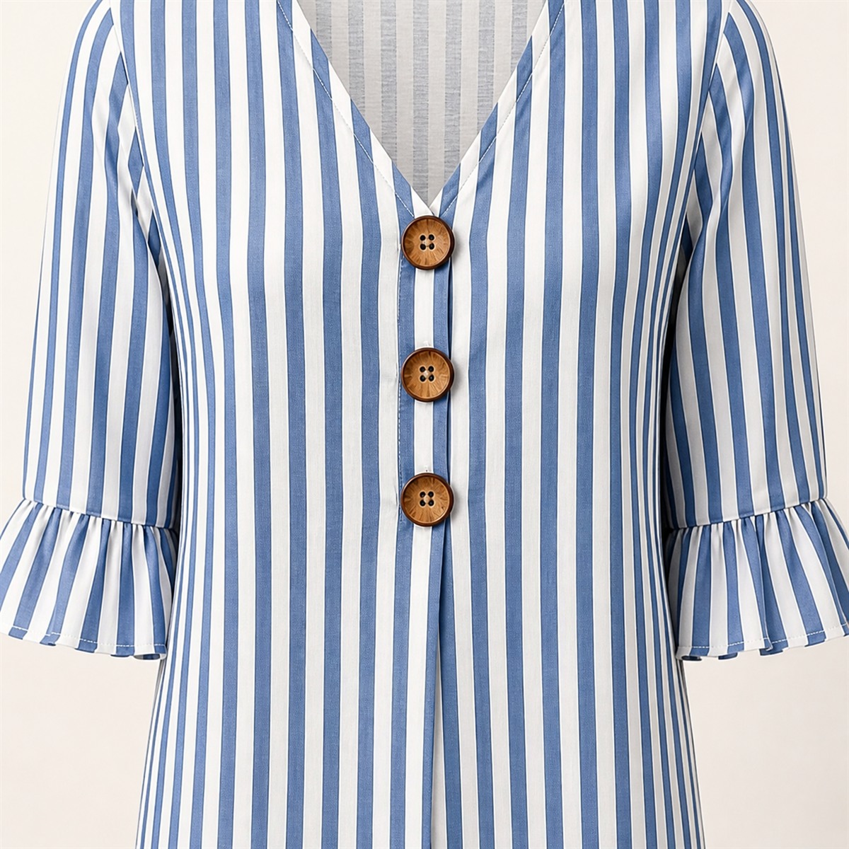 D&eacute;tail de la manche trois-quarts et du volant simple de la blouse bleue