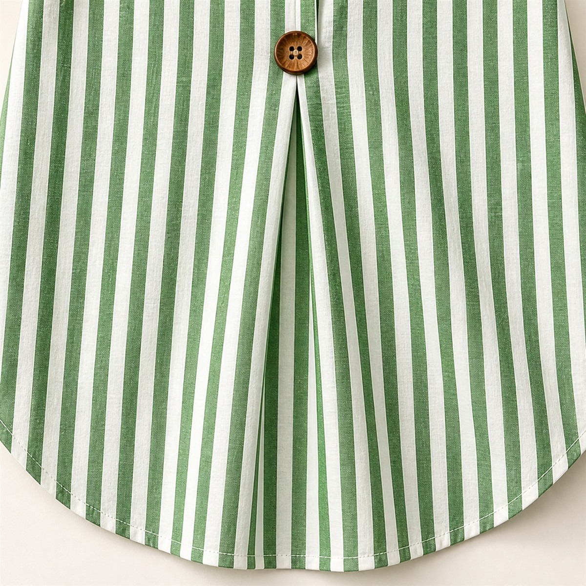 D&eacute;tail des rayures verticales, du pli central et du bas arrondi de la blouse verte