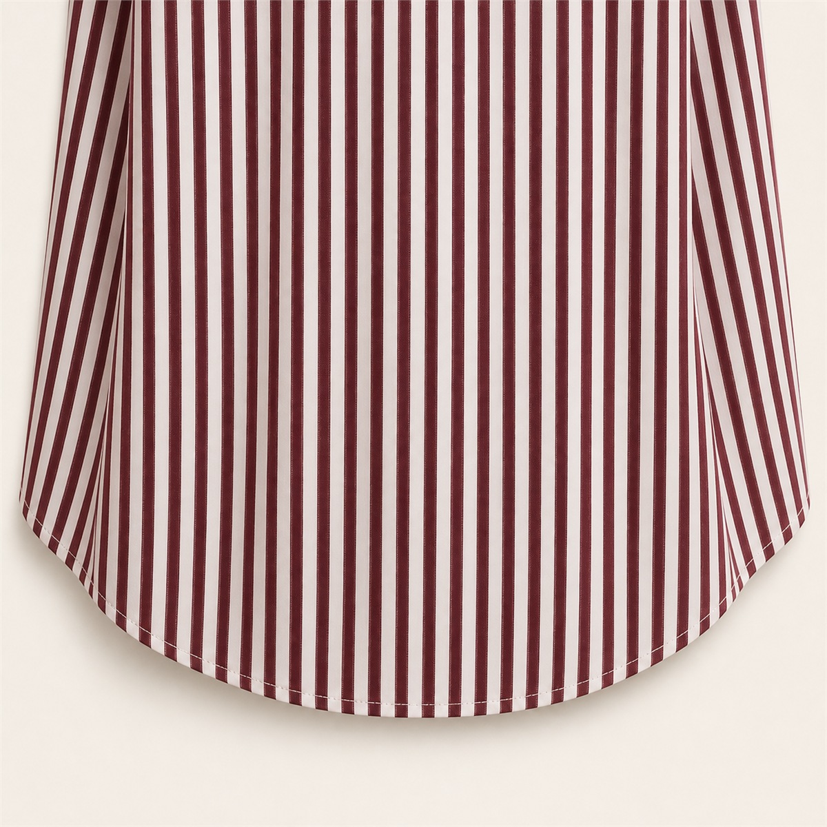 D&eacute;tail des rayures bordeaux verticales et du bas arrondi du polo