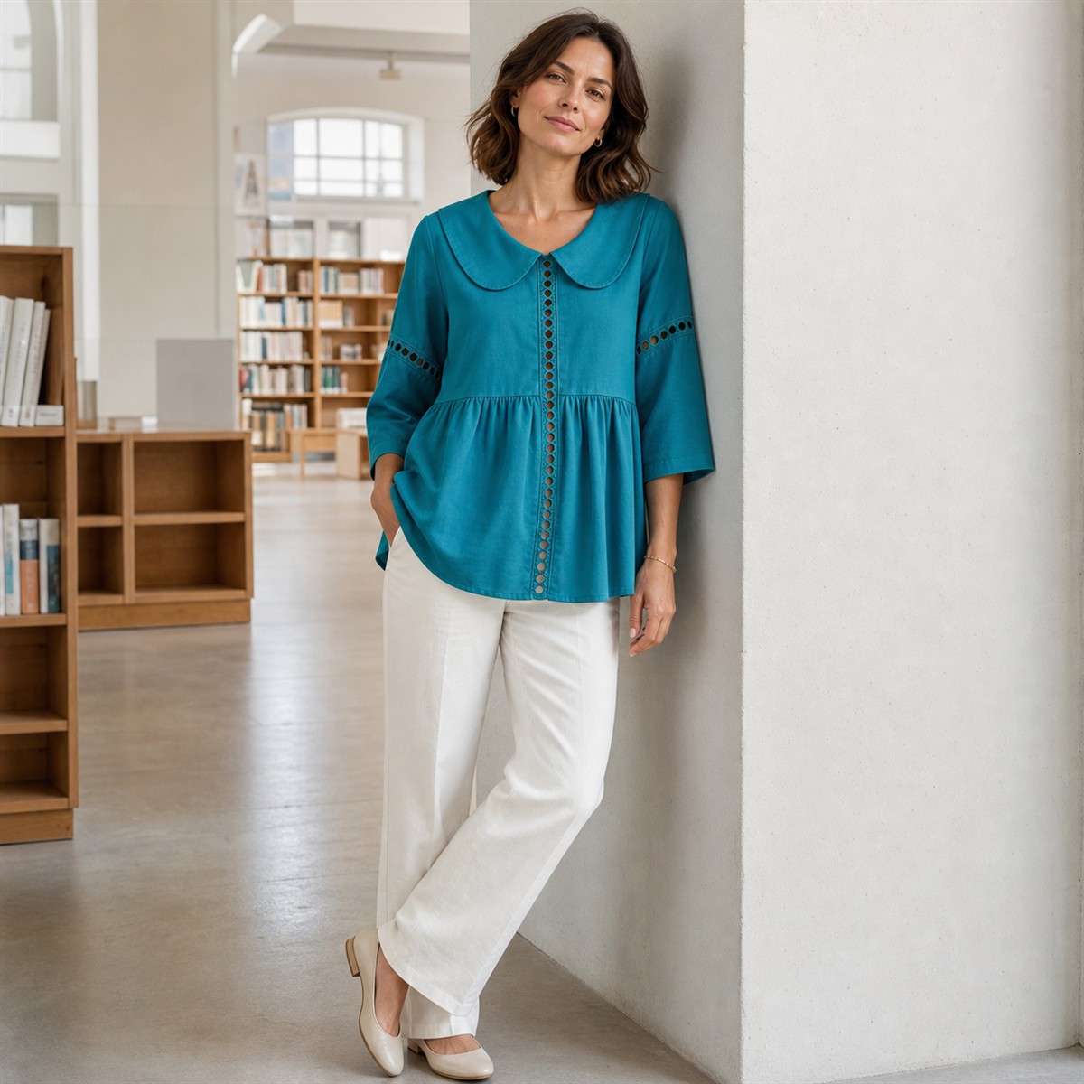 Chemise bleu paon associée à un pantalon écru et des accessoires dorés discrets