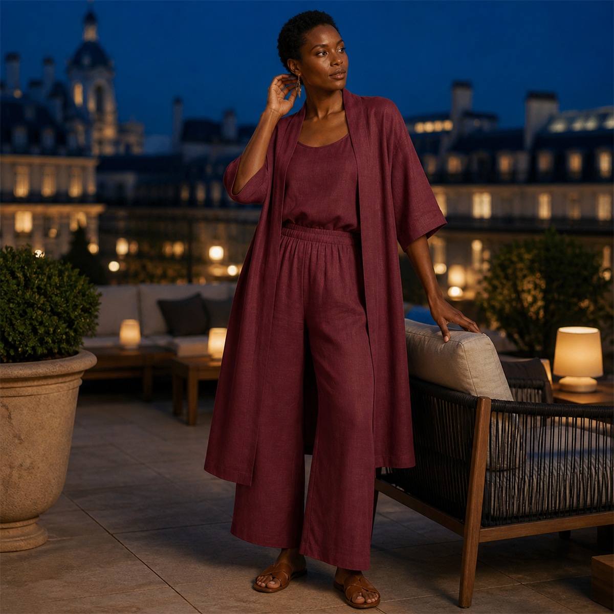 Femme portant l'ensemble trois pièces bordeaux sur une terrasse élégante en soirée