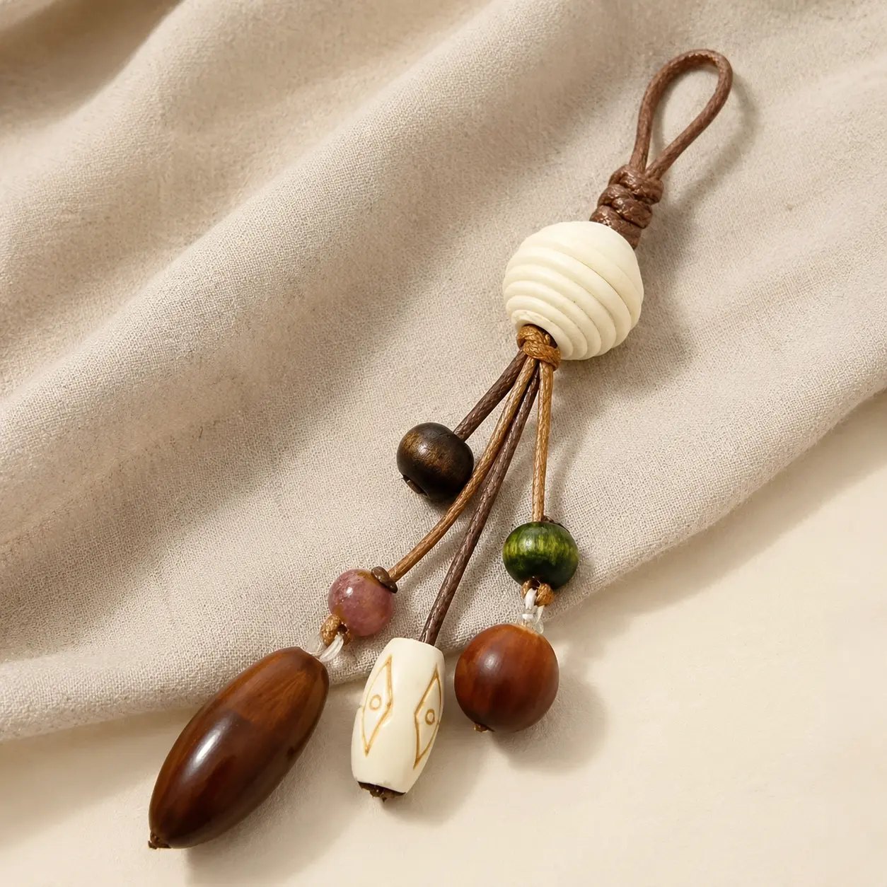 Artisan-inspired beaded bag charmphotographed on soft oatmeal linen