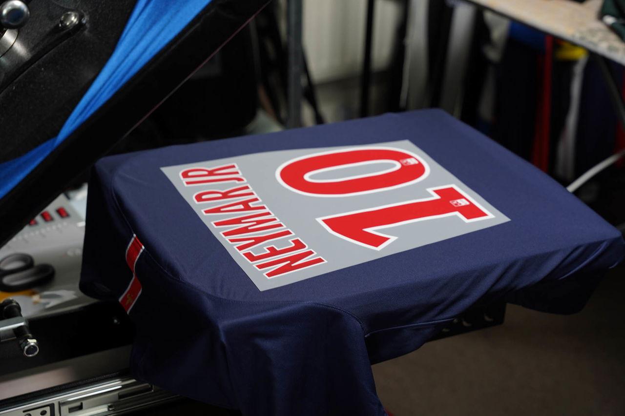 Heat-pressed football shirt player names and numbers on a match kit