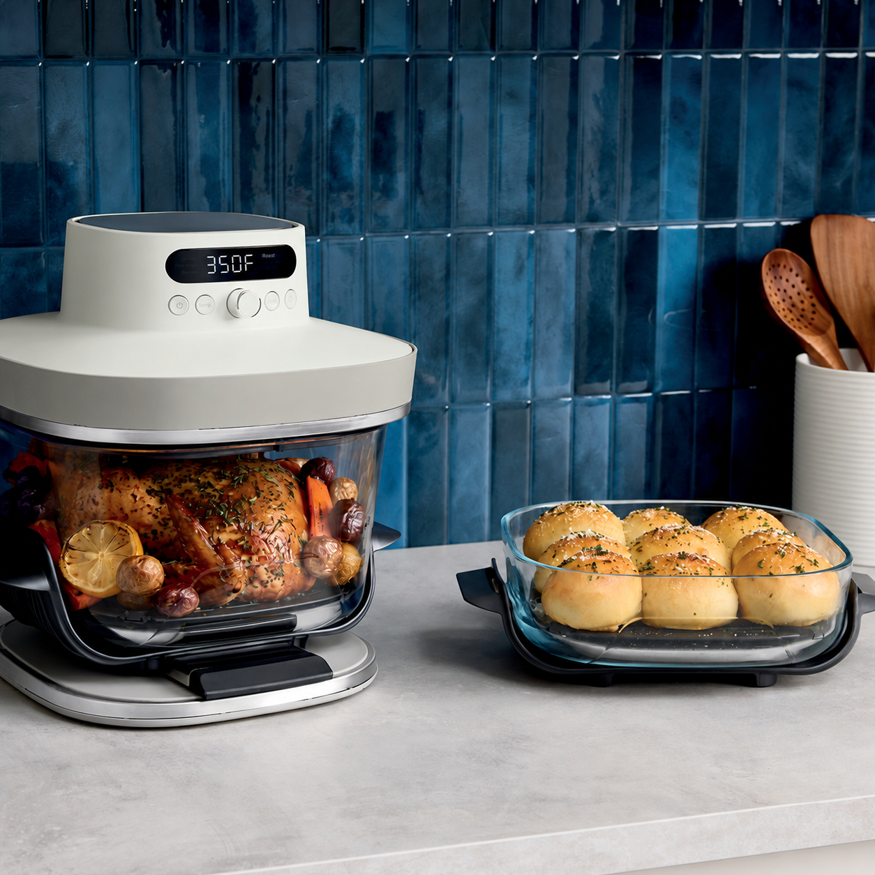 Glass air fryer with roast chicken beside freshly baked rolls