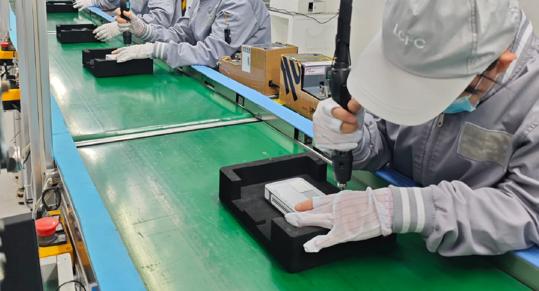 Workers assembling Tiiny Pocket devices on a production line