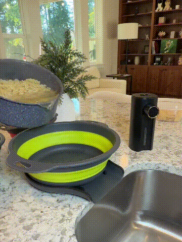 Collapsible draining bowl with self-draining tray being used beside the kitchen sink