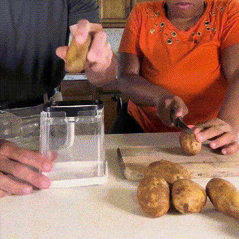 Vegetable and French fry cutter pressing potatoes into uniform sticks
