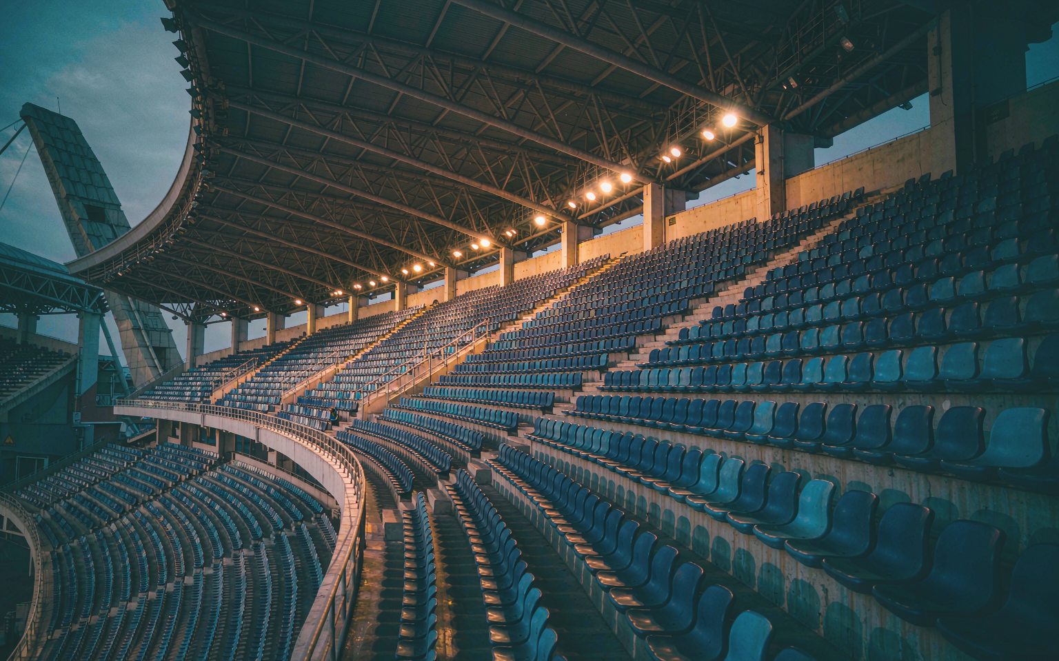 Empty floodlit stadium stand at dusk before kickoff