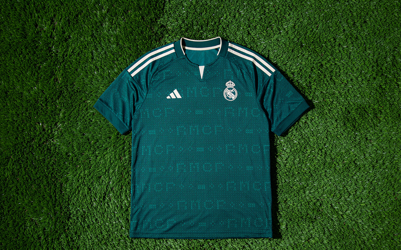 Overhead view of a football shirt laid flat on freshly mown grass under floodlights