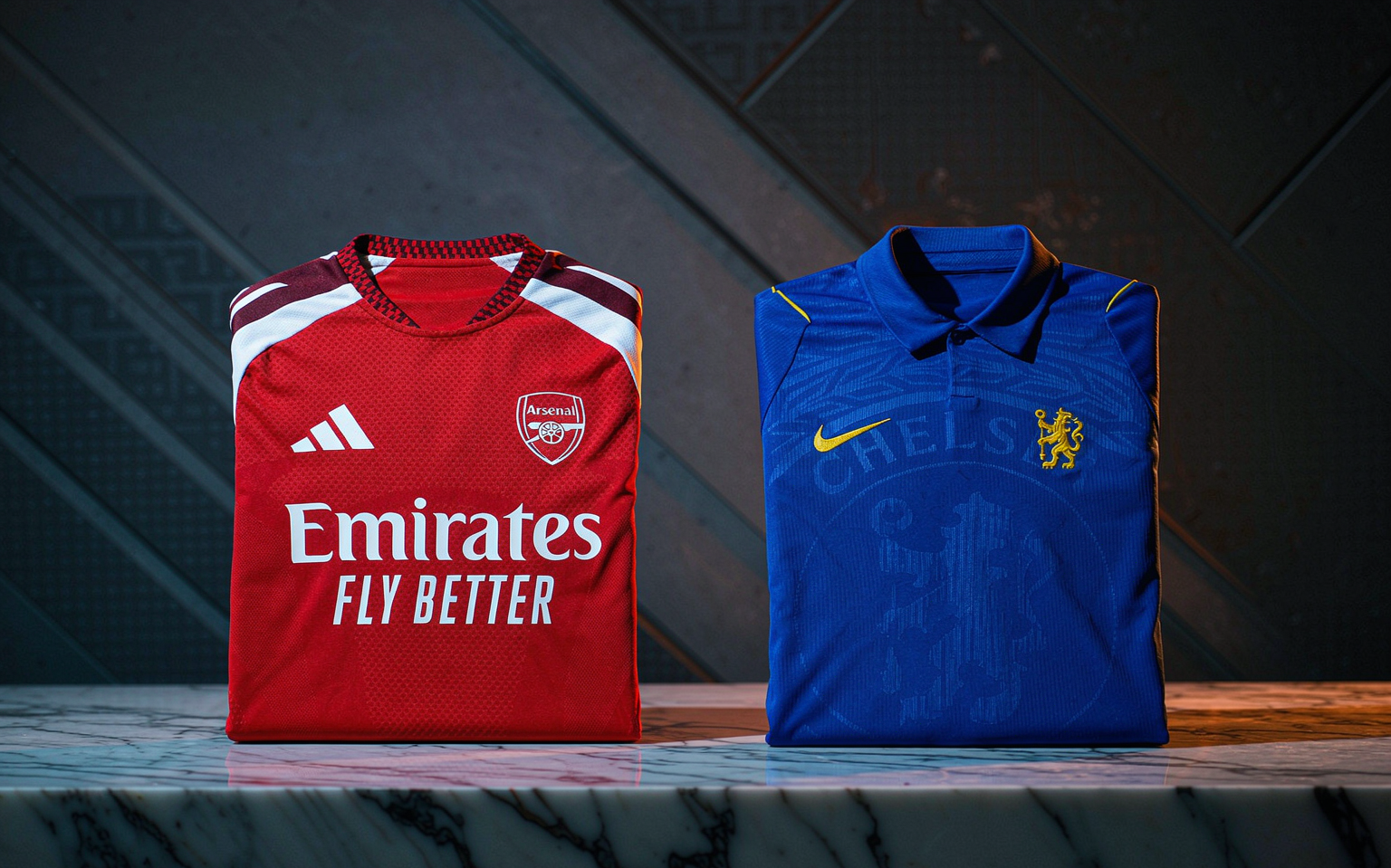 Folded crimson and royal blue jerseys on a dark polished table