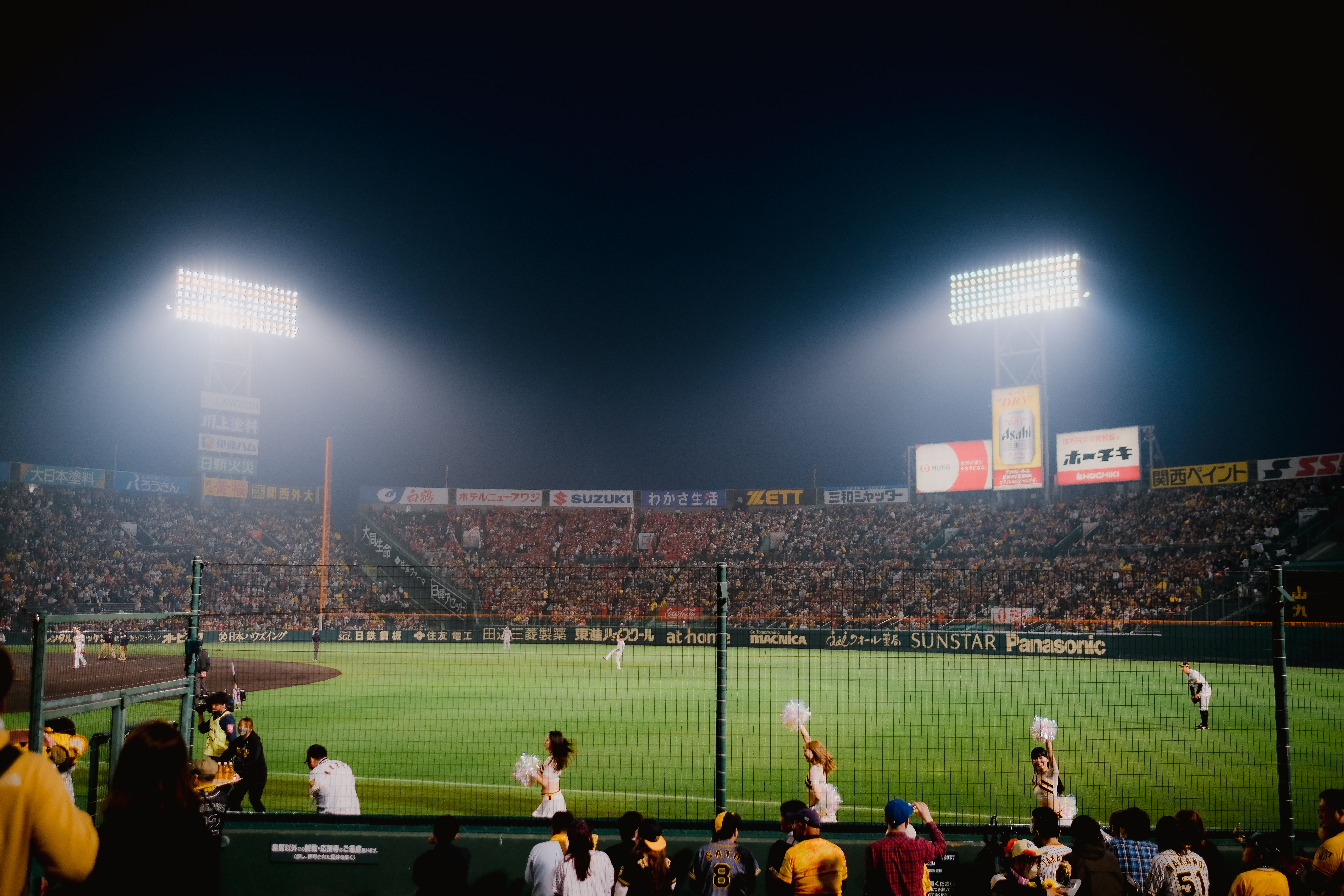 Full baseball stadium glowing under the lights during the late-season push to October