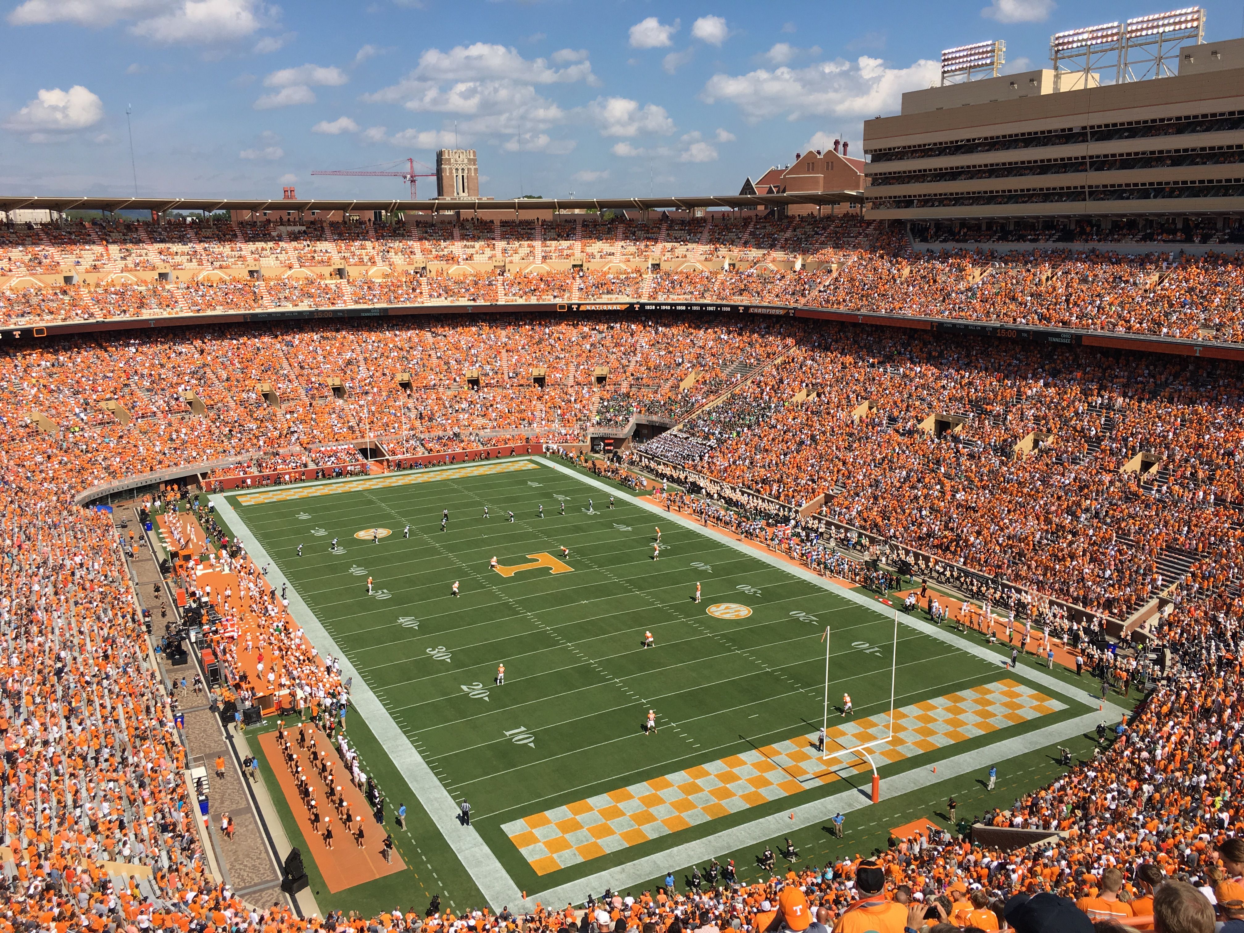 College football fans packed into a stadium bowl celebrating during a game
