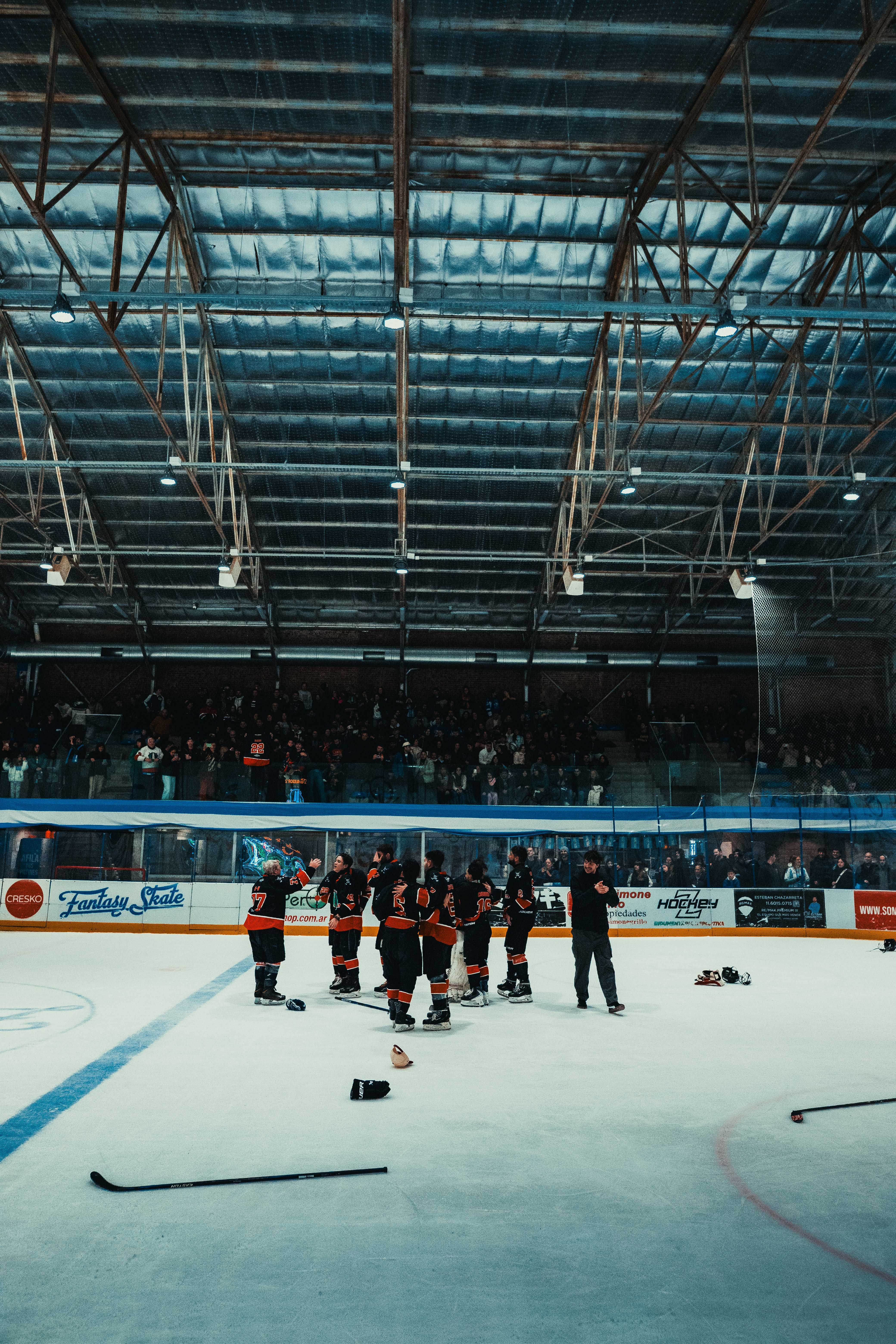 Hockey team celebrating together on the ice in an indoor arena