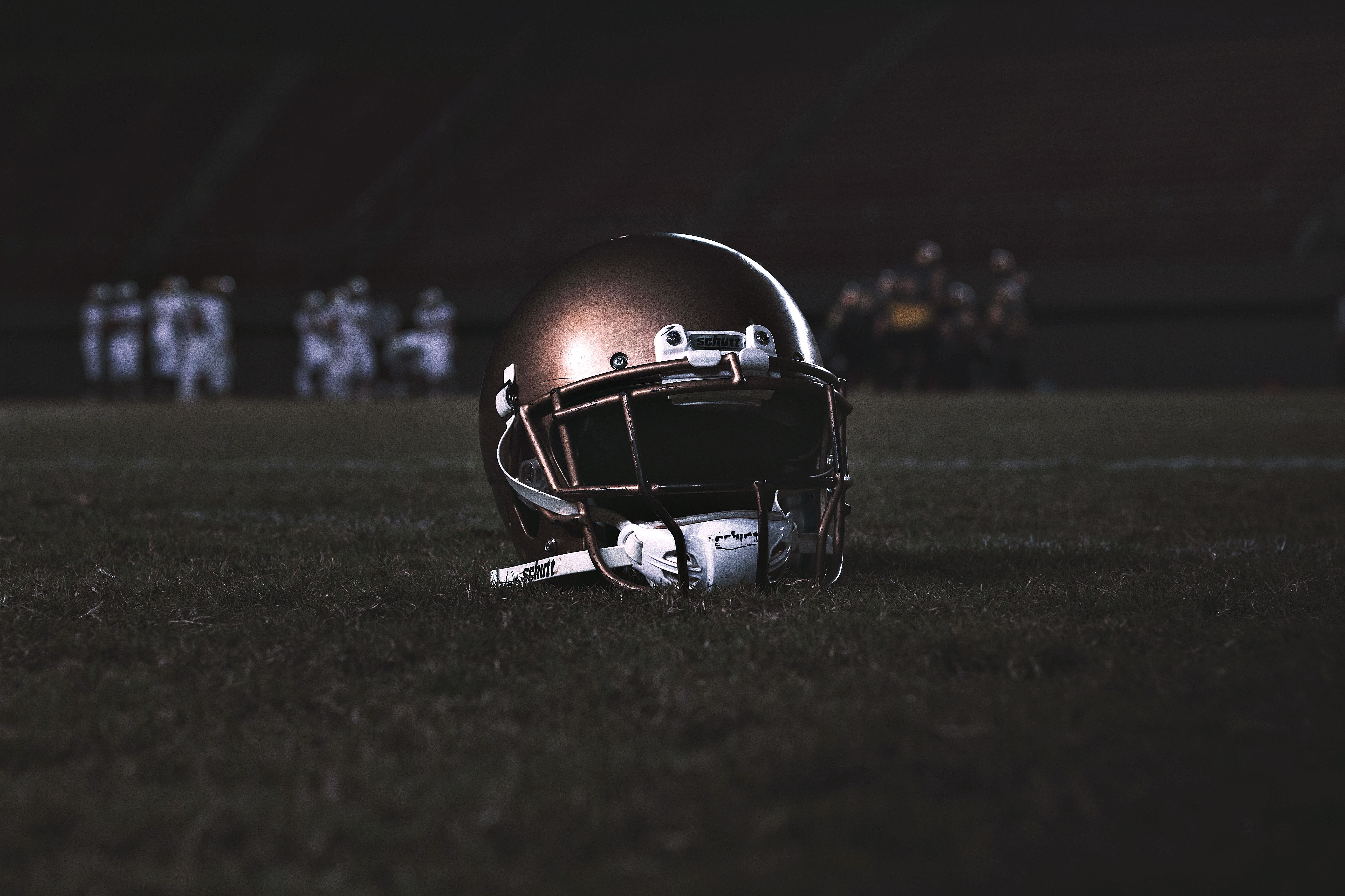 American football helmet resting on the field before kickoff