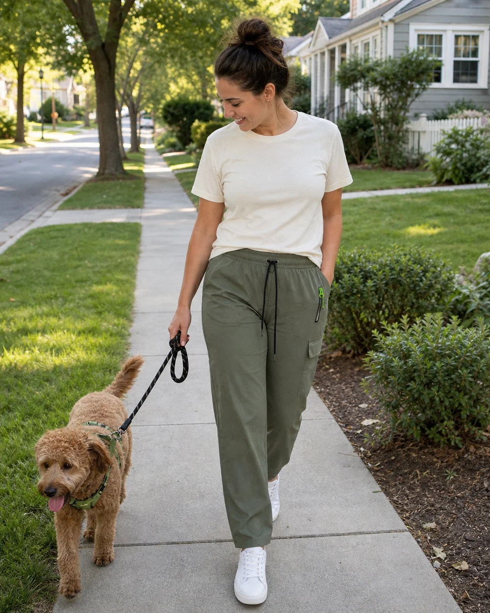 Woman wearing olive cargo pants while walking a dog in her neighborhood