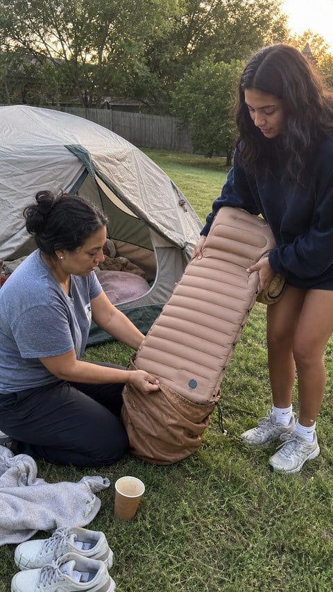 Customer-style snapshot of a family packing the camping mattress after a backyard campout