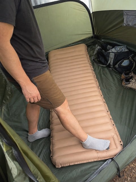 Customer-style snapshot of the built-in foot pump being used inside a tent