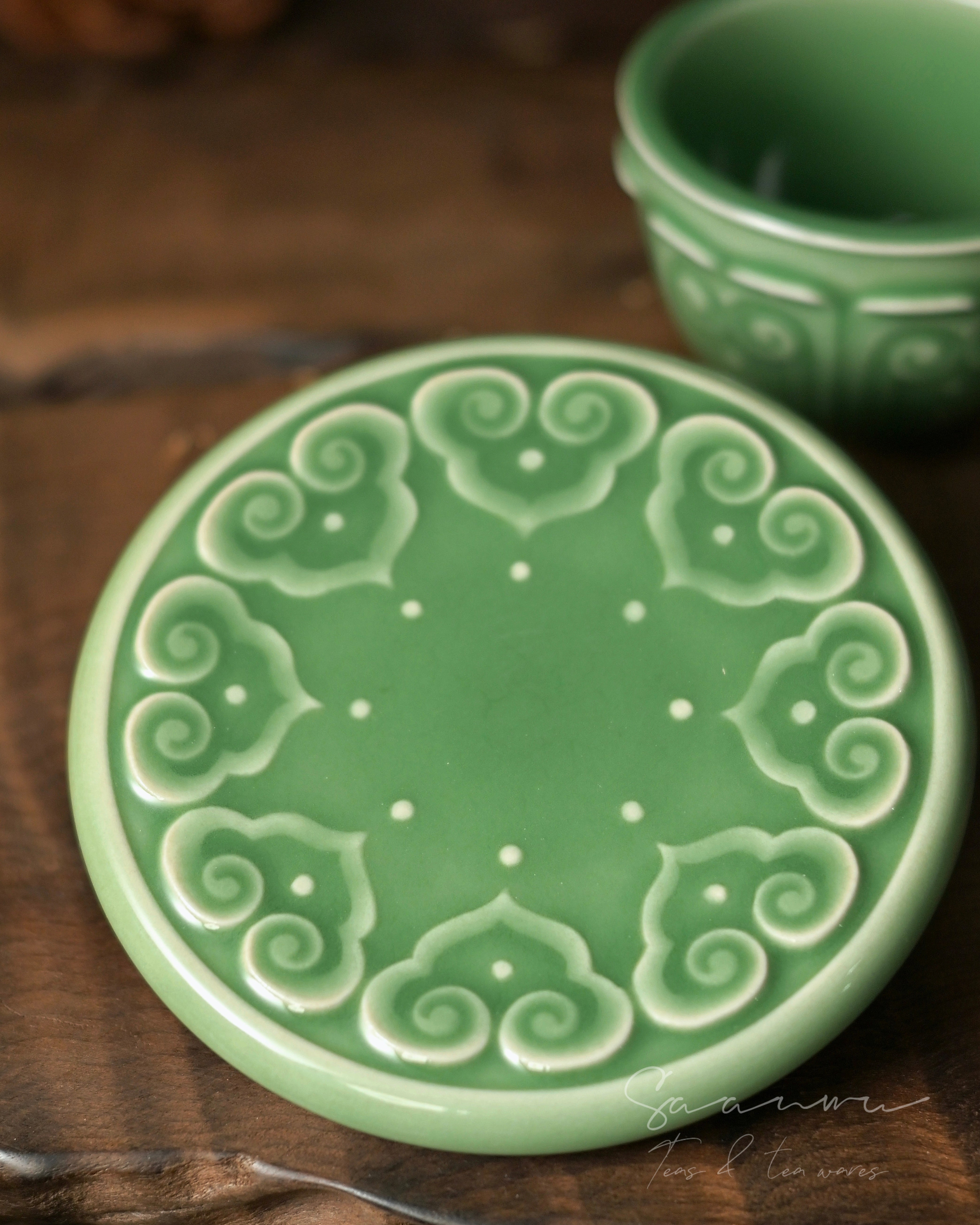 Chinese Longquan celadon tea cup and saucer with jade-like plum green glaze and three-dimensional Baoxiang floral carving. by