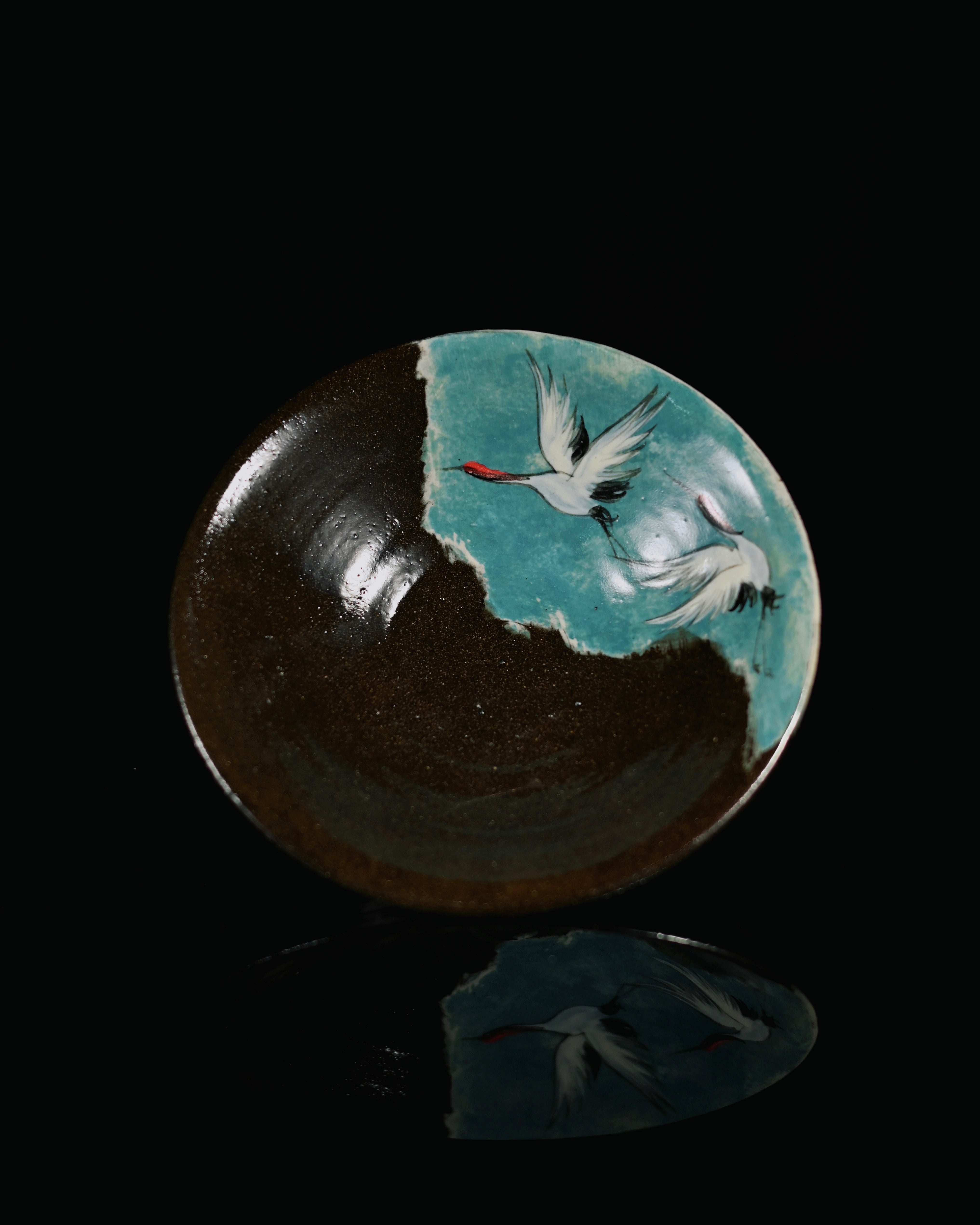 Close-up of the hand-painted red-crowned cranes soaring across a sky-blue background on the drip tray. by Kungfuyang