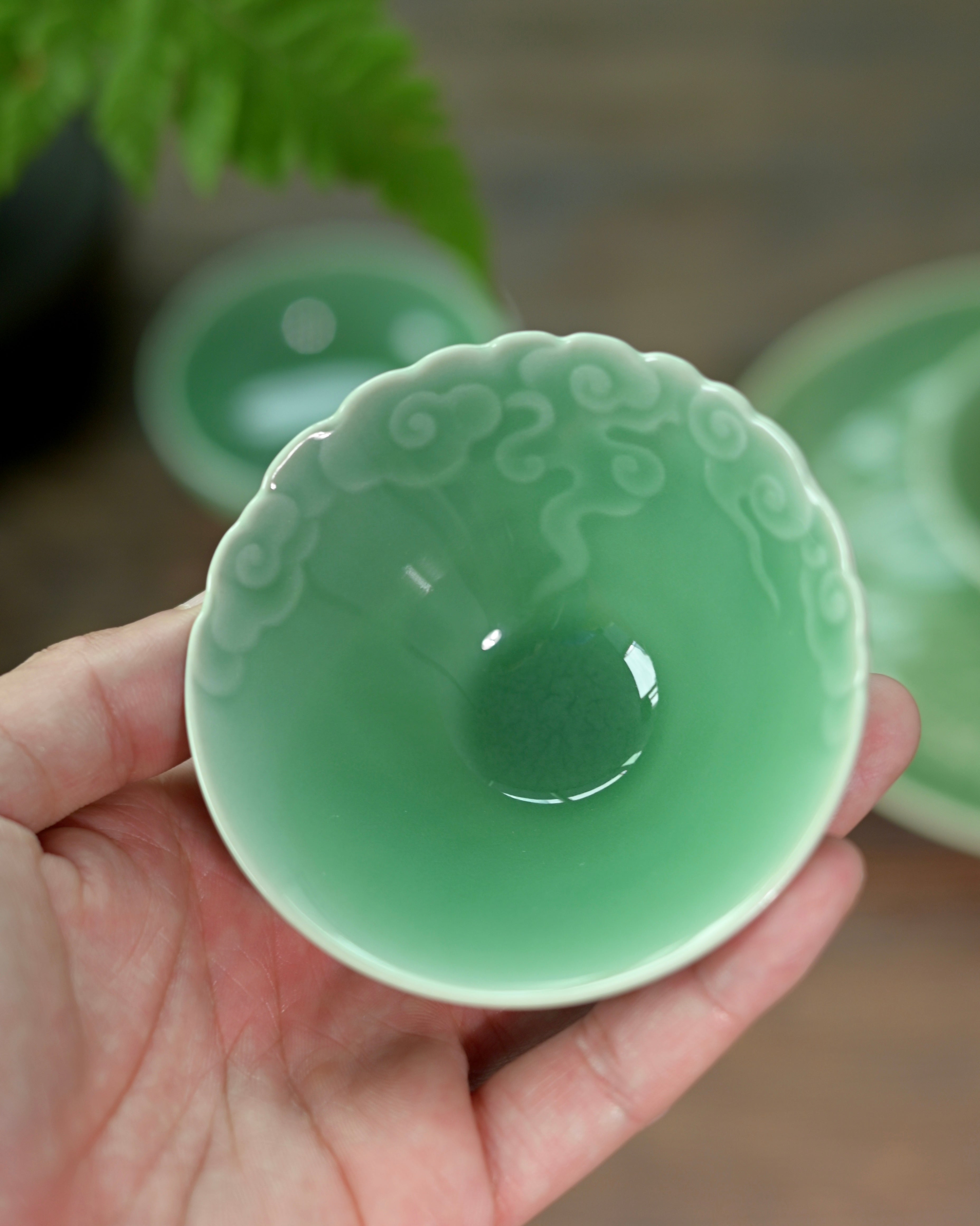 Meiziqing glaze teacup with three-dimensional cloud sculptures, combining spiritual symbolism with functional design by