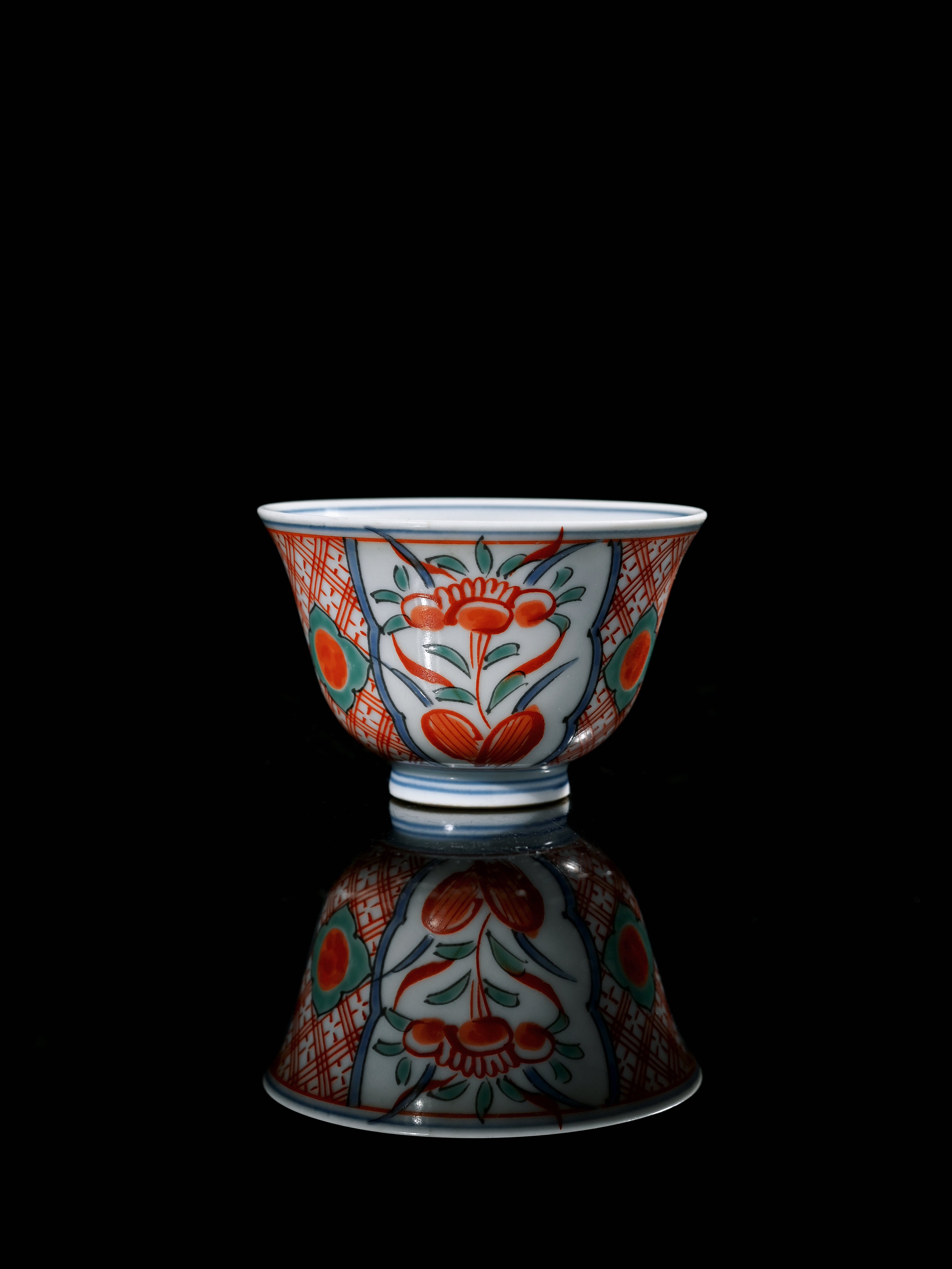 Autumn leaves and a stylized rock formation painted on a Kutani cup, showing fine brushwork and warm earthy tones. by