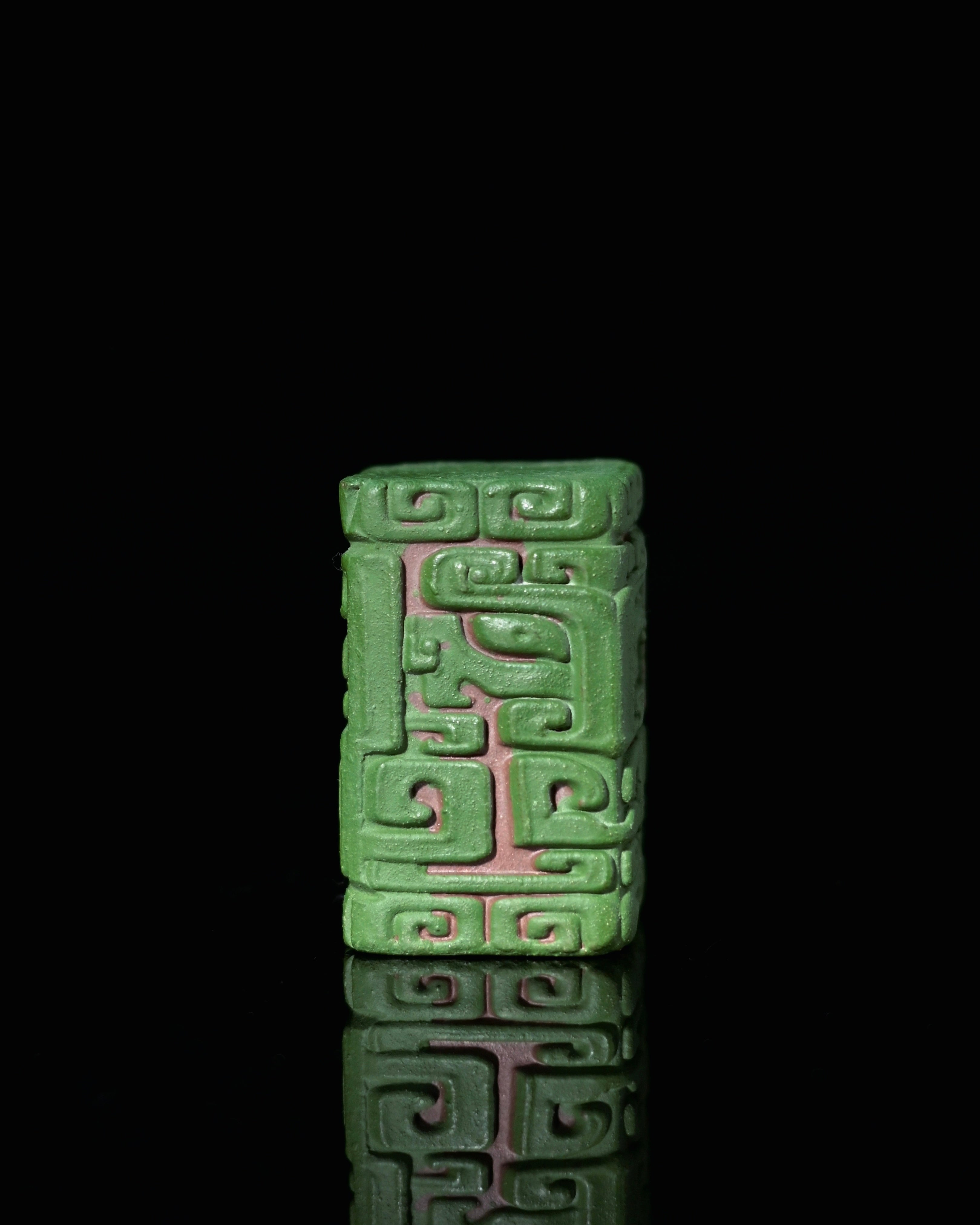 Vermilion clay body with green slip exterior showing color contrast between cool surface and warm carved lines by Kungfuyang