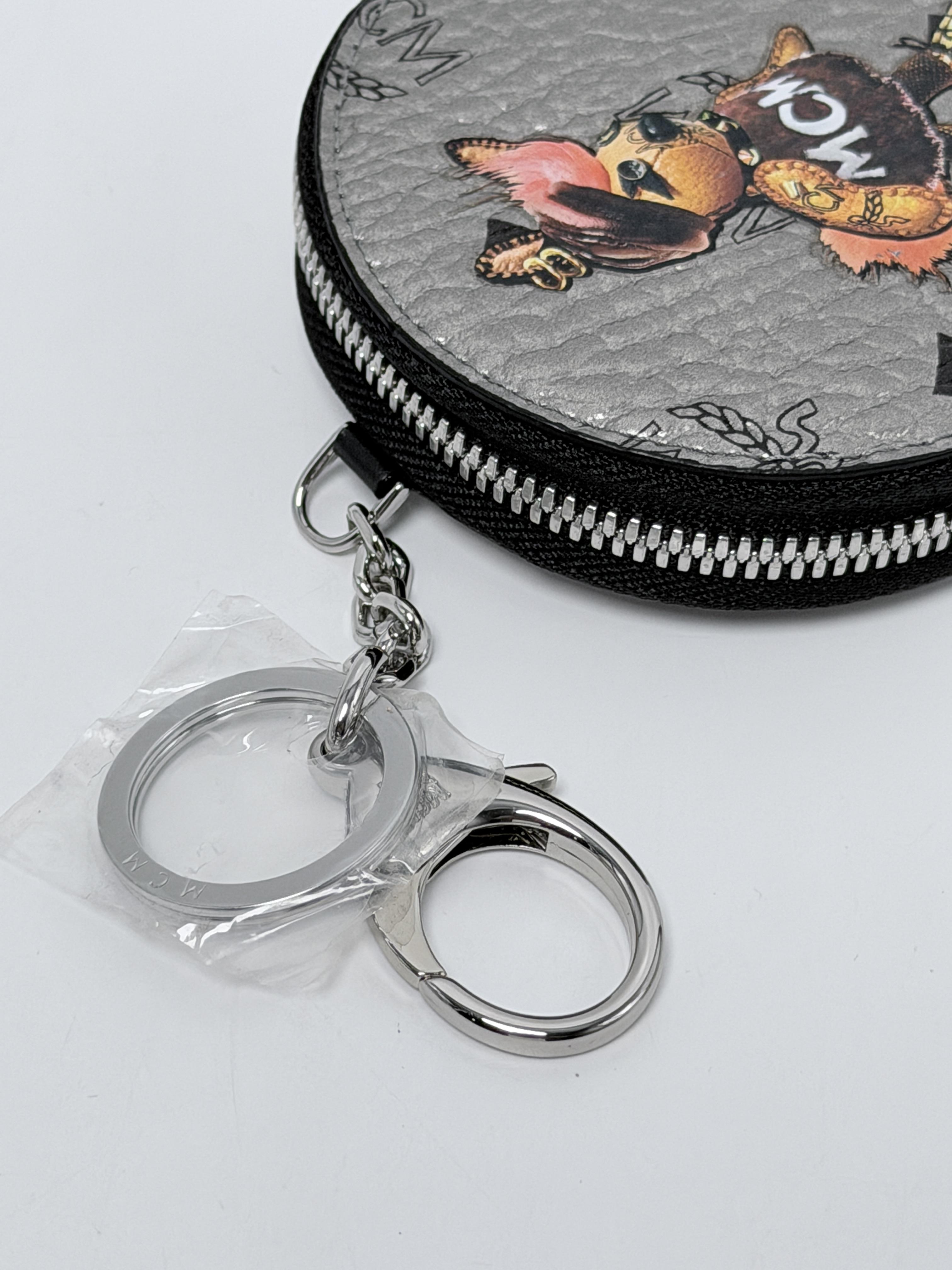Authentic M Pup Round Coin Pouch Bag Charm MYZBSXL02 Metallic Silver Dark Grey Visetos Monogram Canvas with French Bulldog Graphic & Orange Pom Pom Tail JD1411MCM
