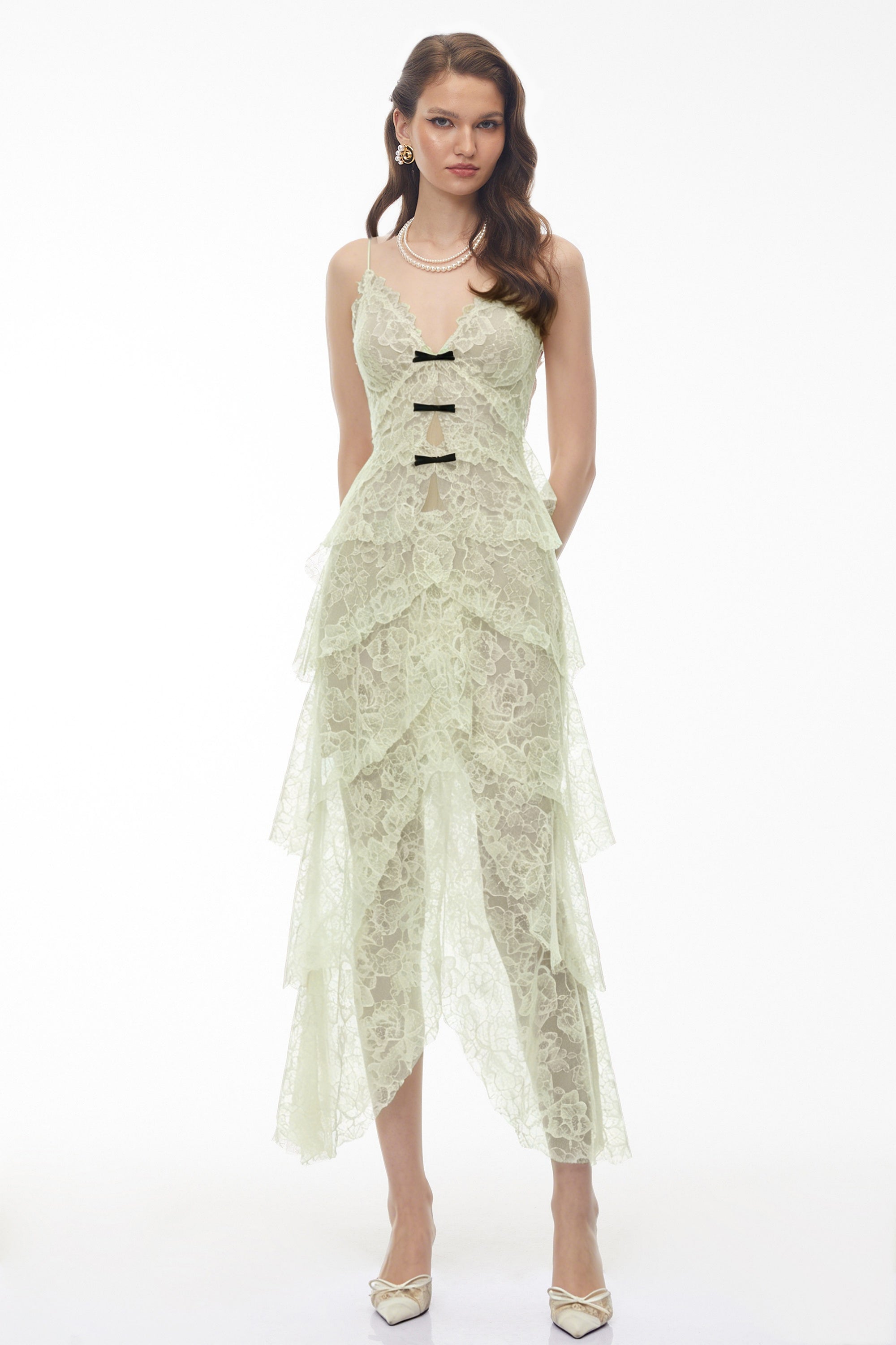 Sage green tiered lace dress with black bow accents