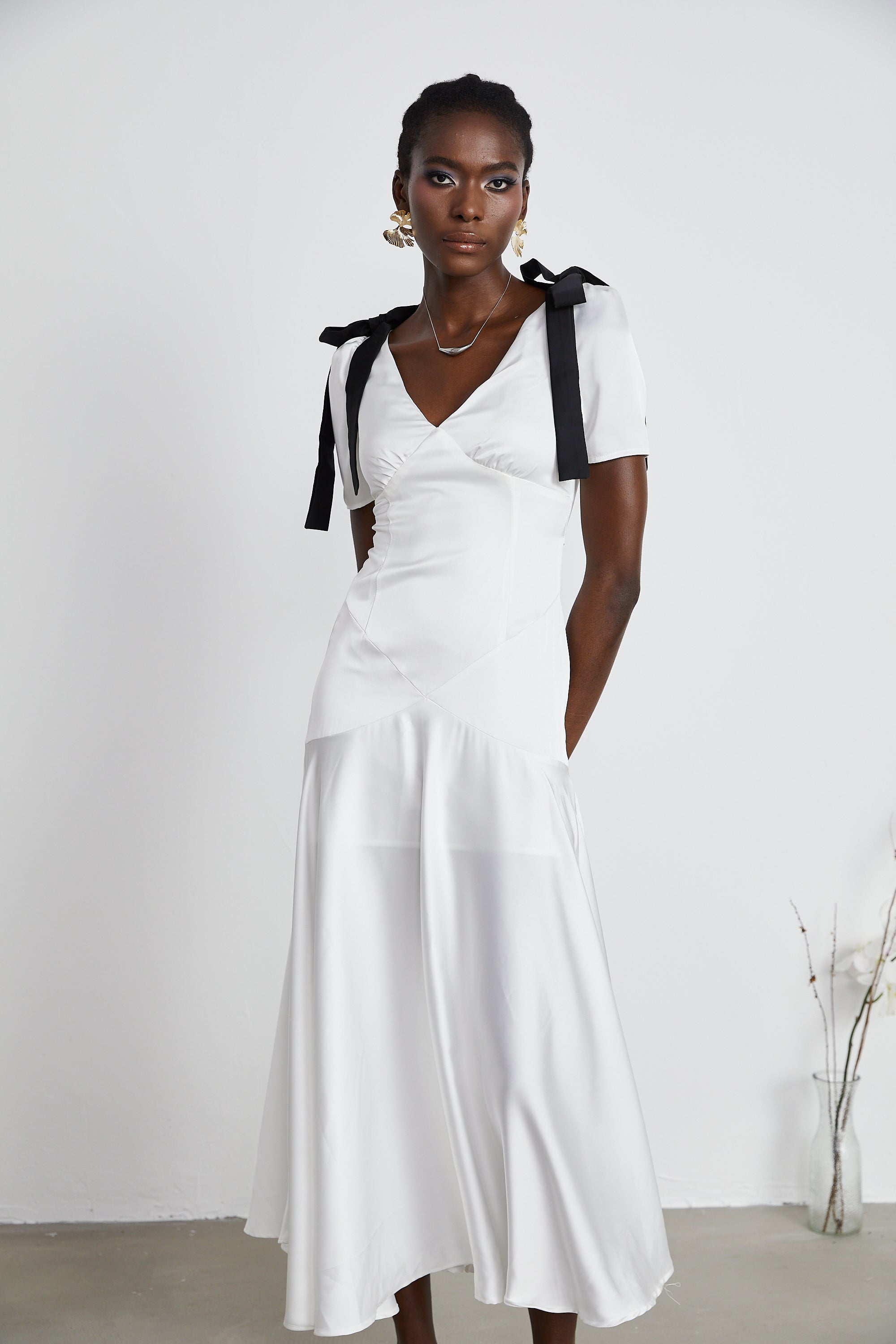White satin V-neck midi dress with black bow shoulder straps