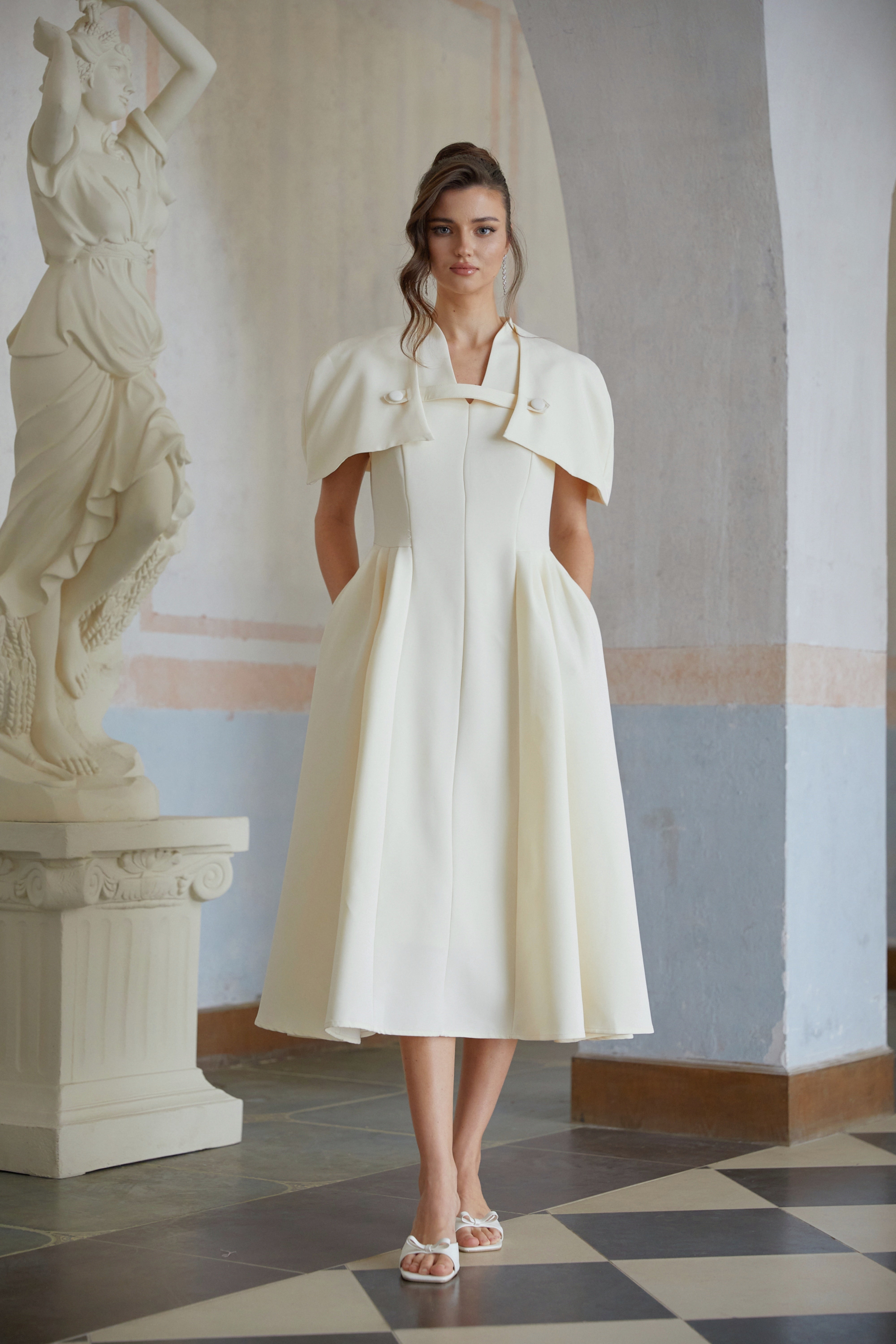 Cream midi dress with a structured capelet overlay and button details