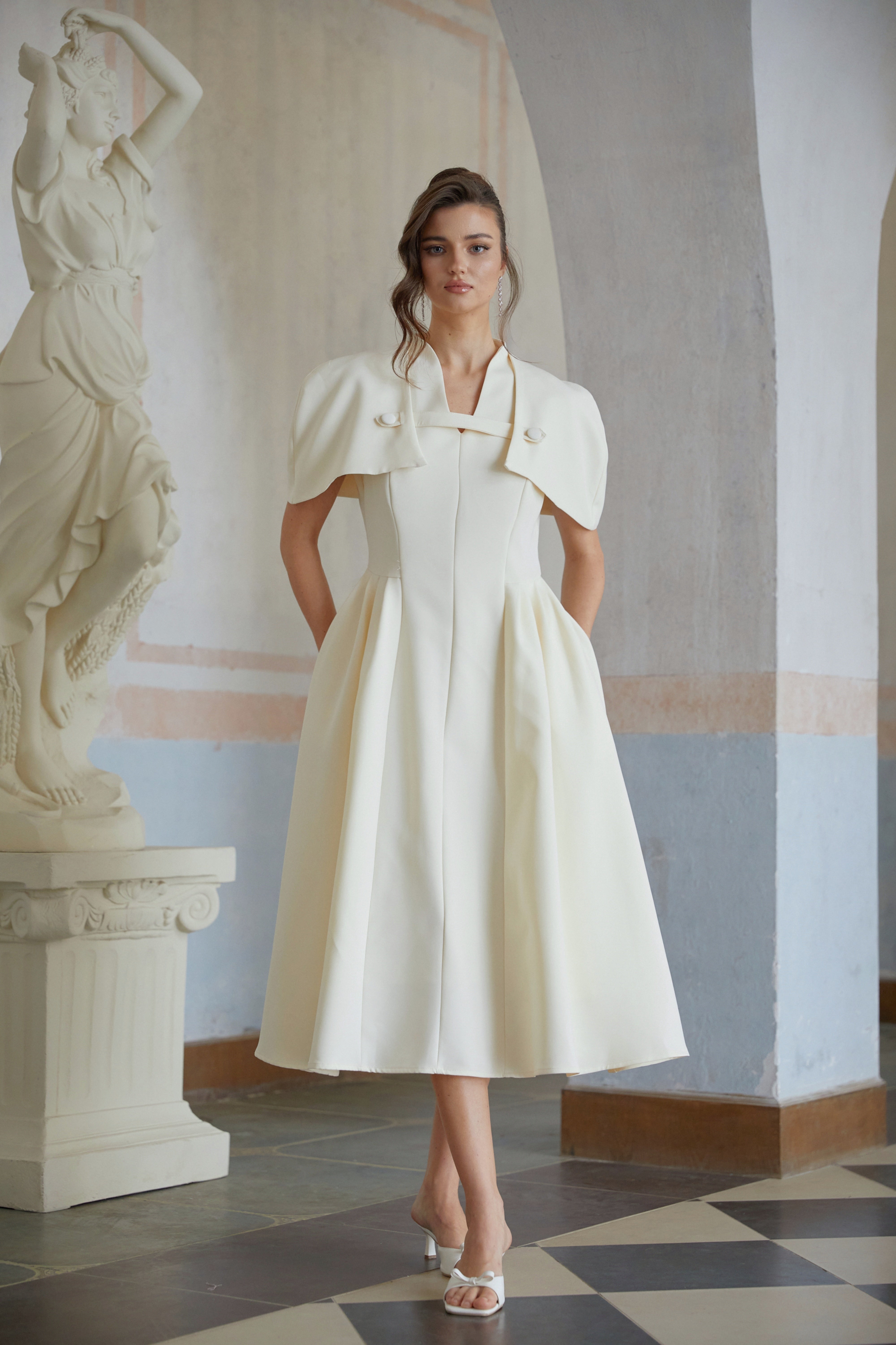 Cream midi dress with a structured capelet overlay and button details